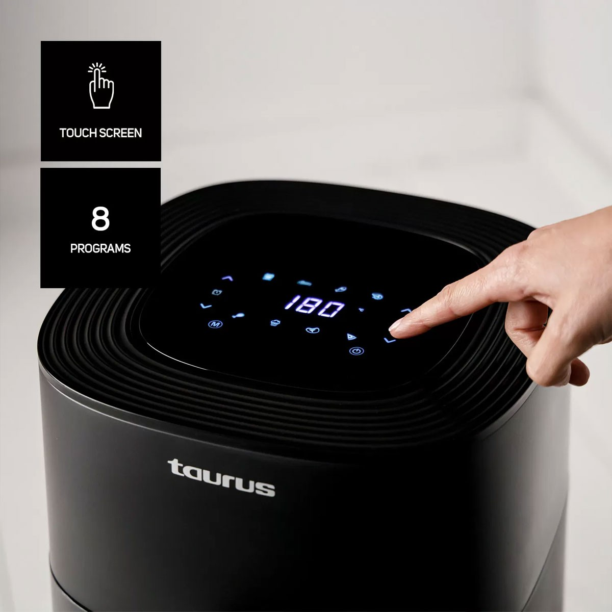 Una friggitrice ad aria Taurus nera con display touchscreen, che mostra 180 gradi e 8 programmi.
