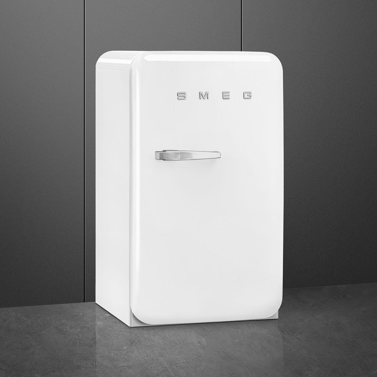 Frigorífico Smeg blanco con tirador cromado, sobre fondo gris oscuro.