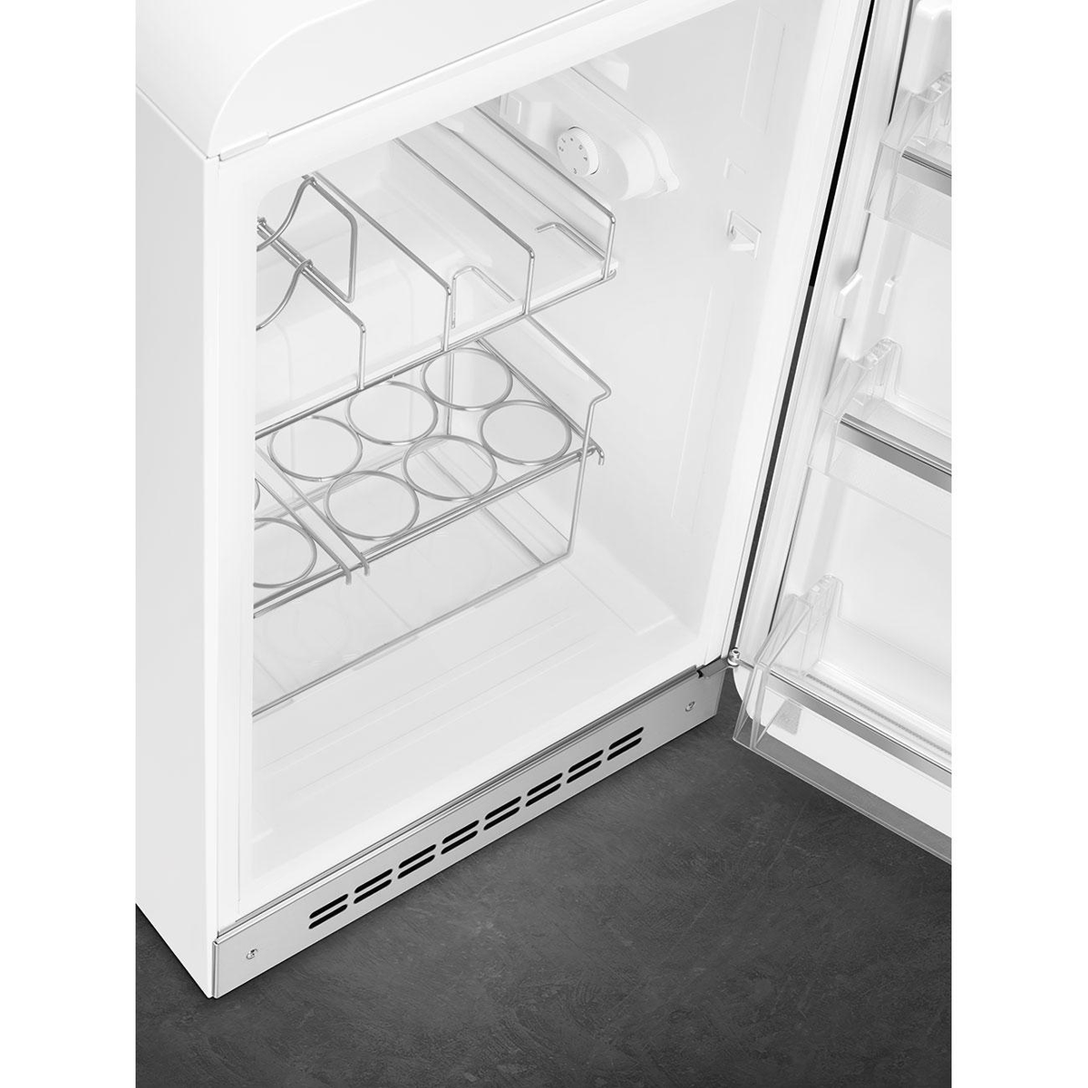 Puerta de refrigerador blanca abierta, mostrando estantes y compartimentos. Contenedores plateados dentro.