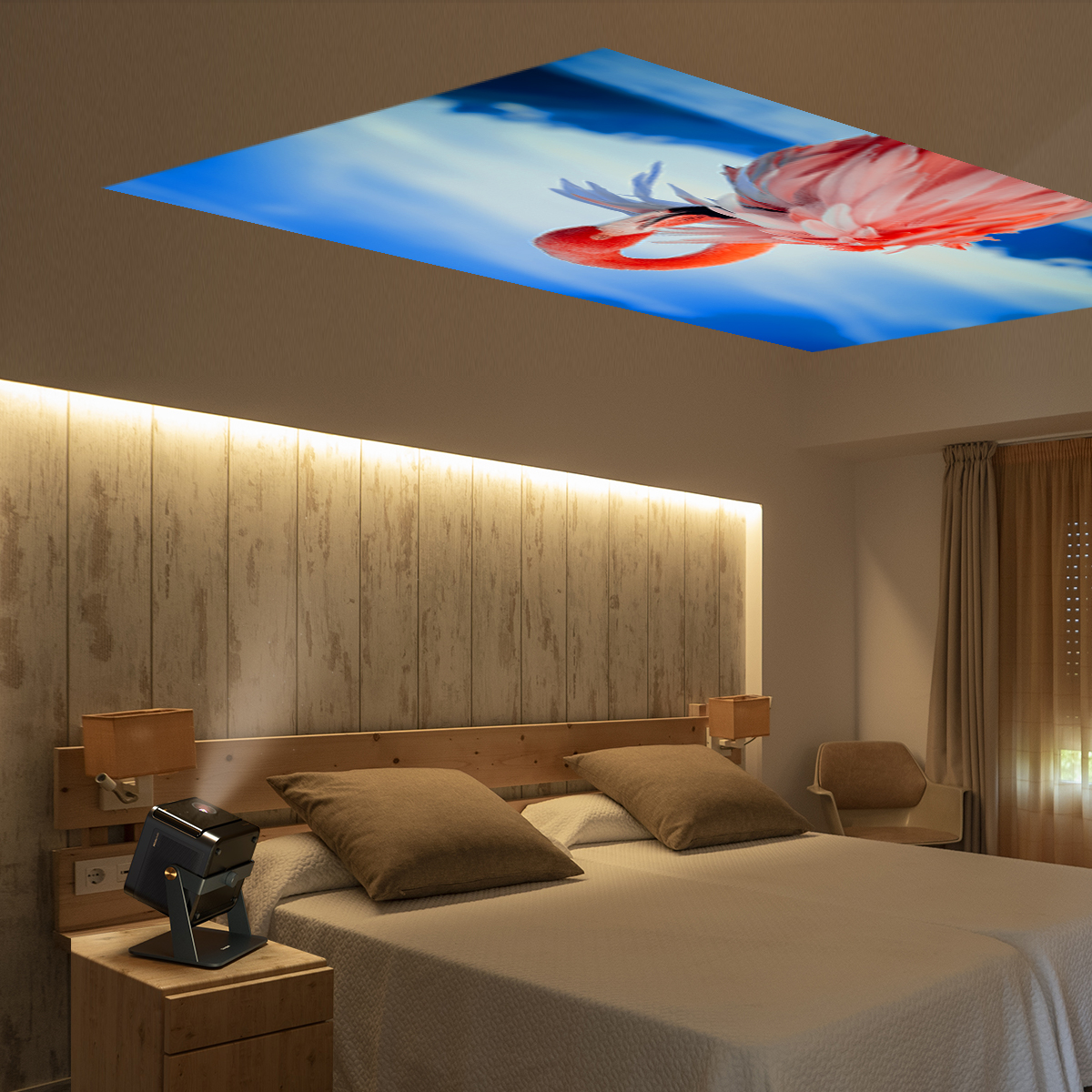 Sypialnia z flamingiem na suficie, łóżko, szafka nocna i projektor.