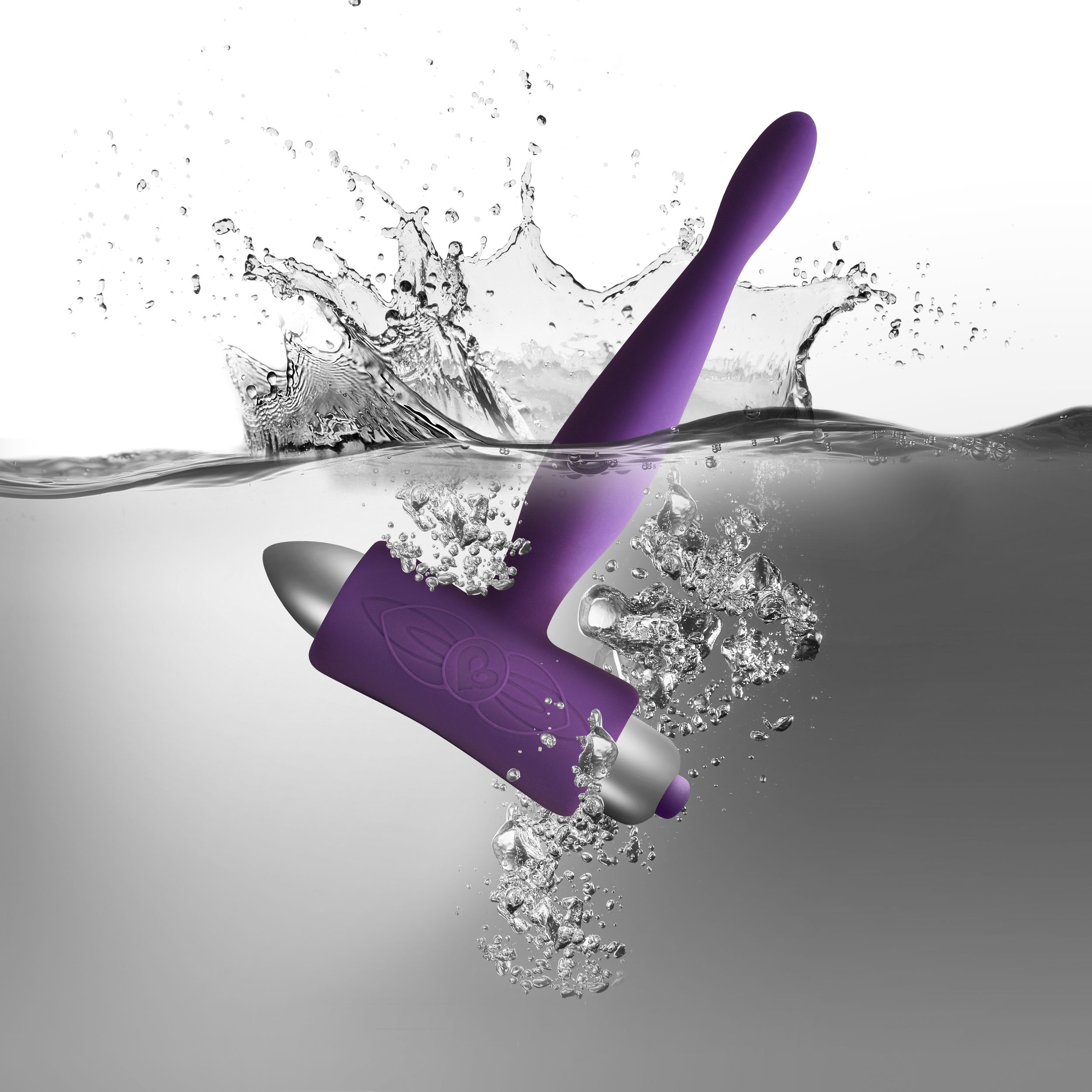 Lila Sexspielzeug unter Wasser, mit Wasserspritzern und Blasen.
