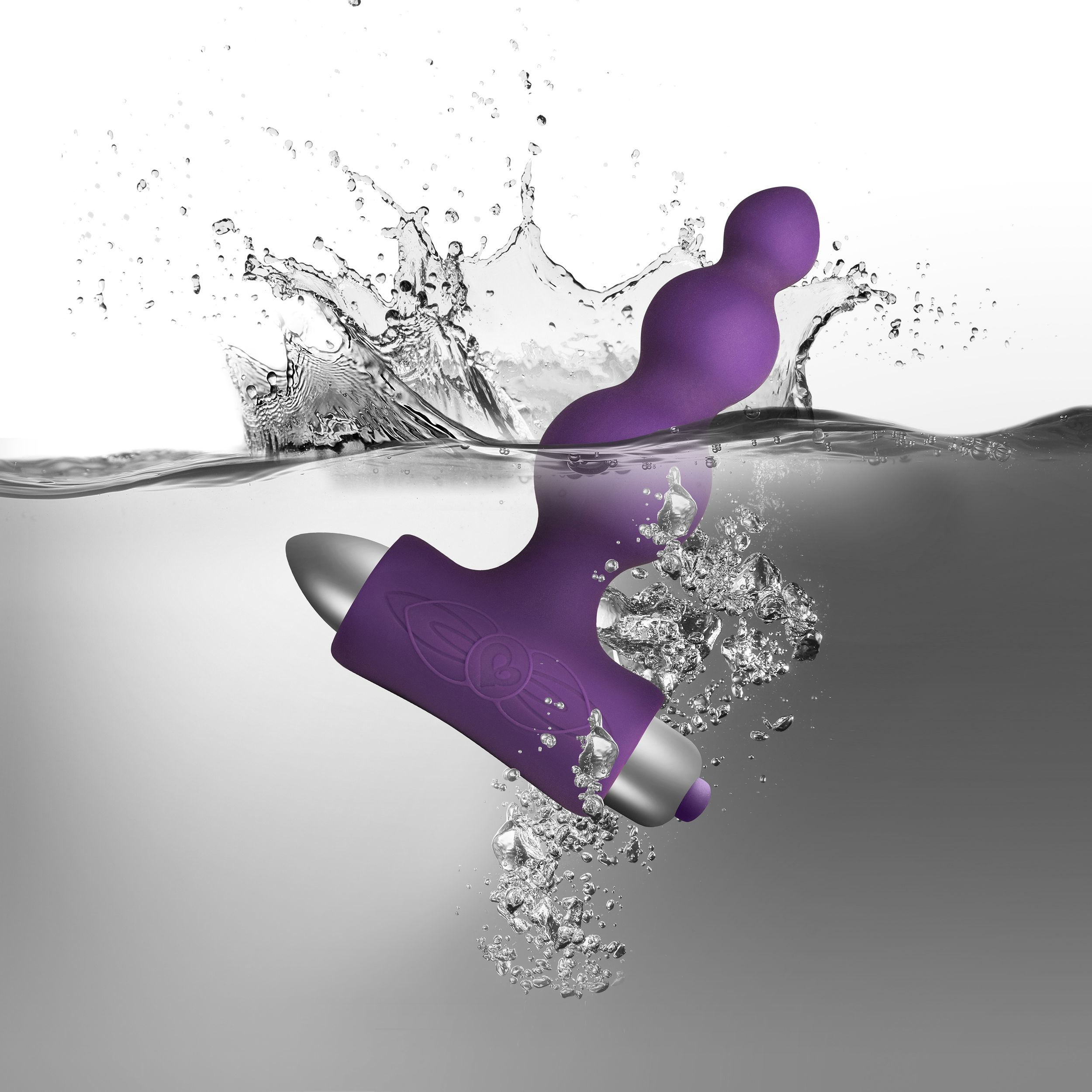 Lila wasserdichter Vibrator unter Wasser, mit Wasserspritzer und Blasen.