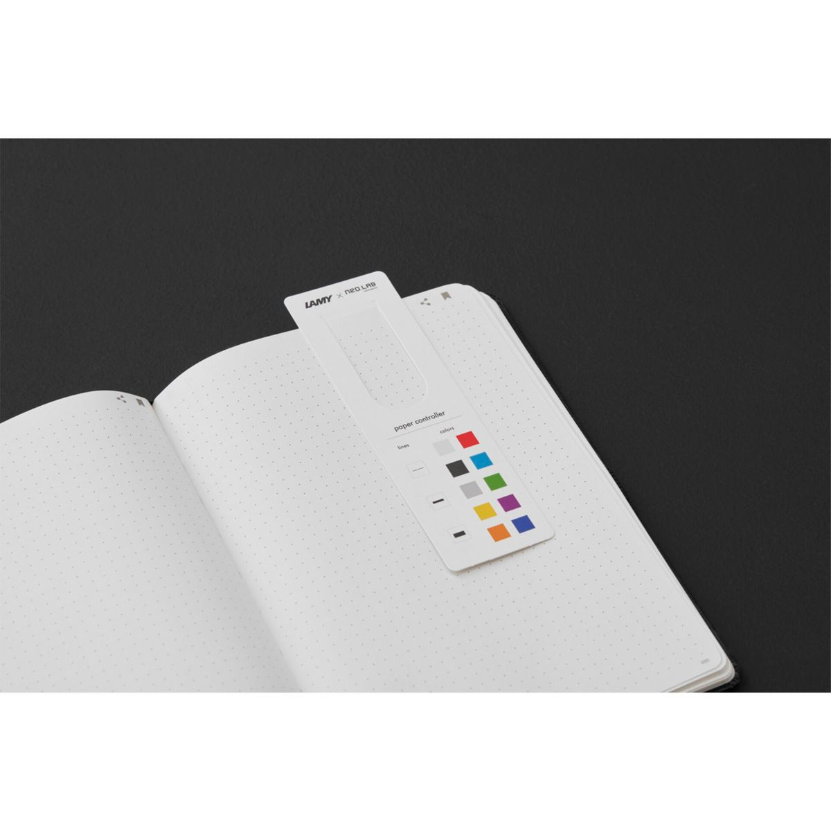 Ein Notizbuch mit einem Farbkarten-Lesezeichen. Das Lesezeichen zeigt eine Farbpalette und das LAMY NEO Lab-Logo.