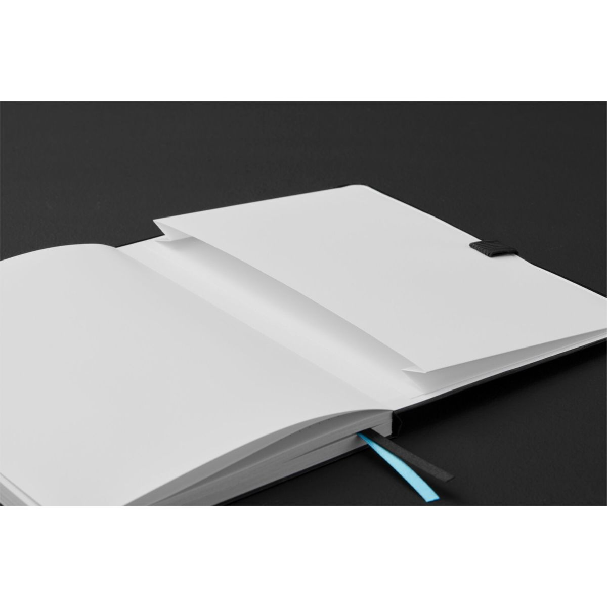 Offenes Notizbuch mit leeren weißen Seiten, schwarzem Rücken und blauem Lesezeichen.