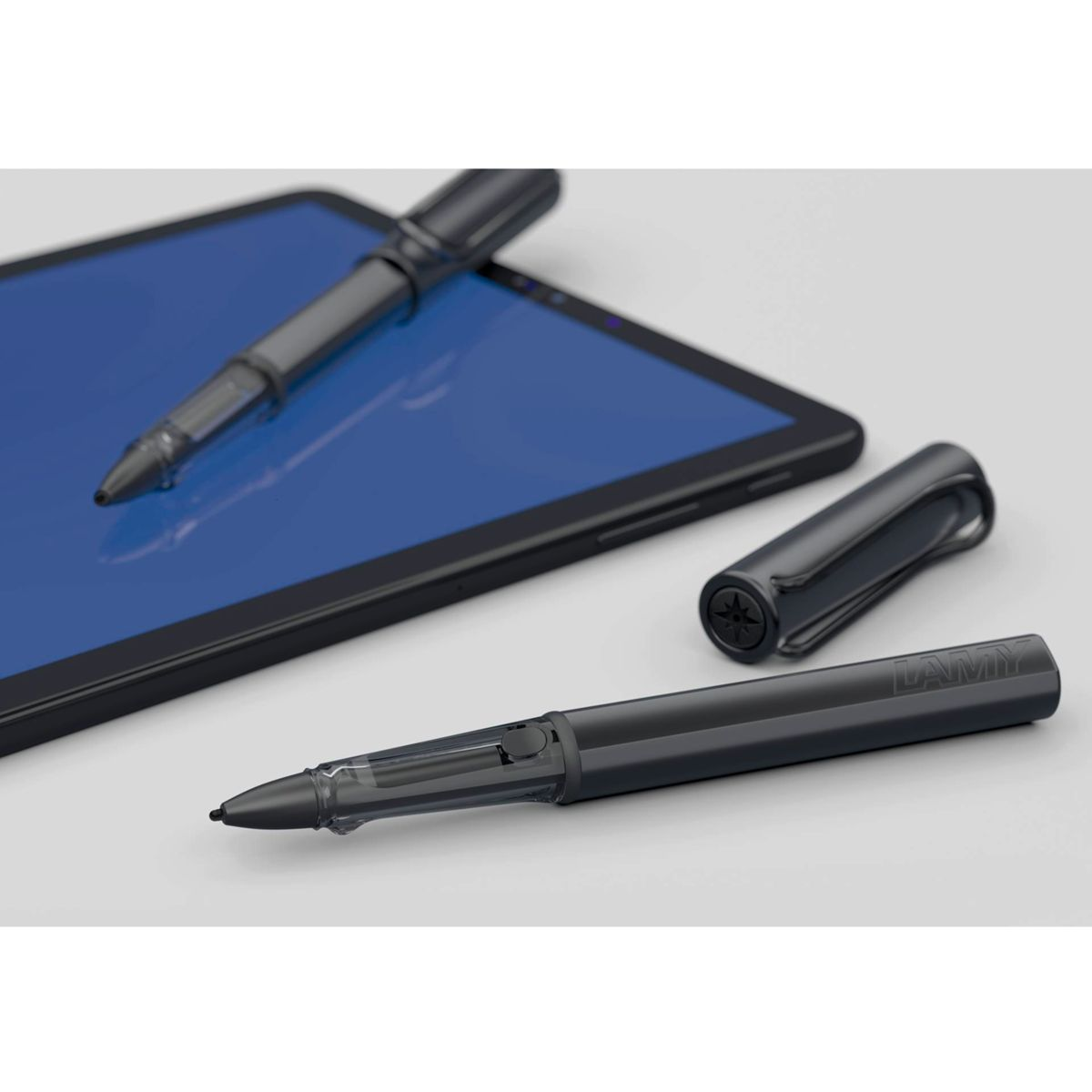 Schwarzer Stift und Stylus auf einem blauen Tablet. Weißer Hintergrund.