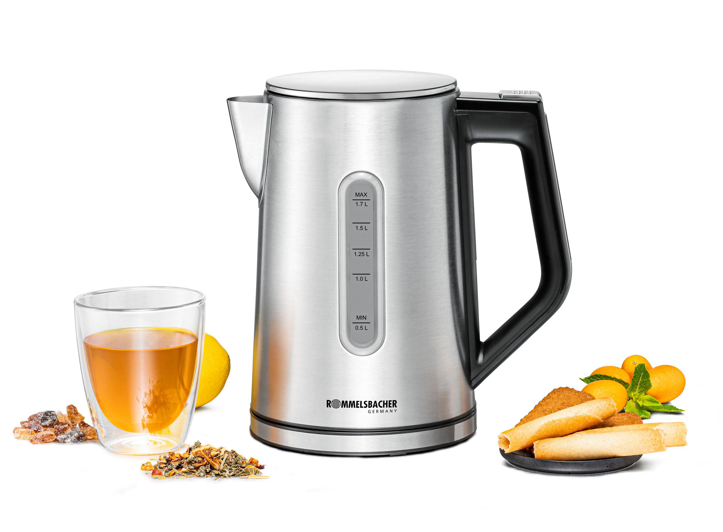 Czajnik elektryczny ze stali nierdzewnej ze szklanką herbaty, cytryną i ciasteczkami z boku.