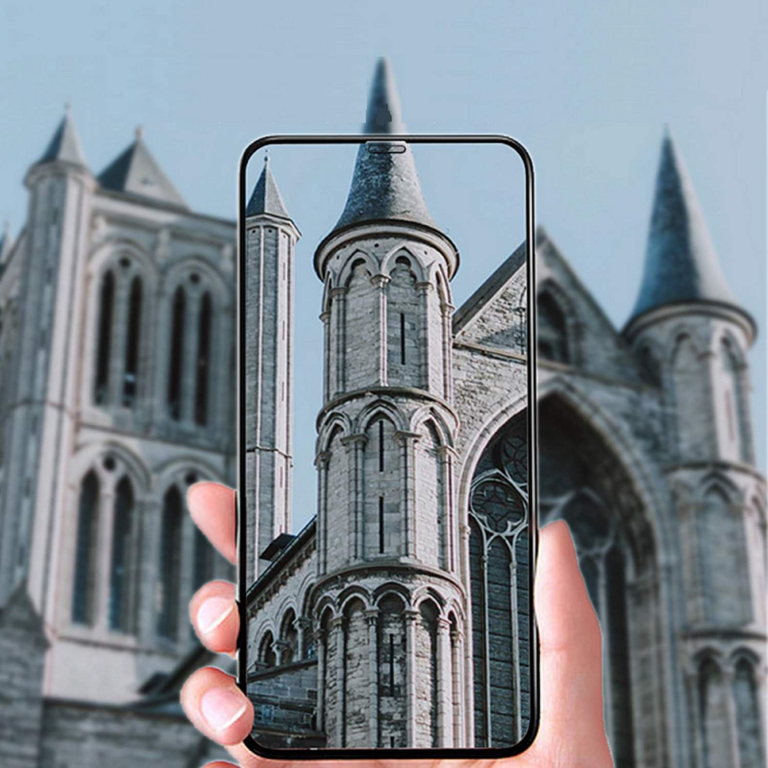 Eine Hand, die ein Telefon hält, das eine Kirche zeigt, mit verschwommenem Kirchenhintergrund.