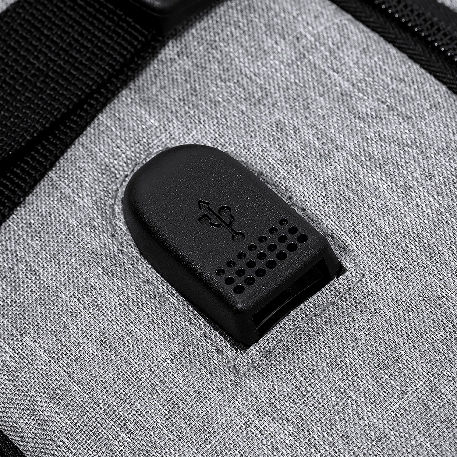 Primer plano de mochila con puerto USB. El puerto es negro y rectangular.