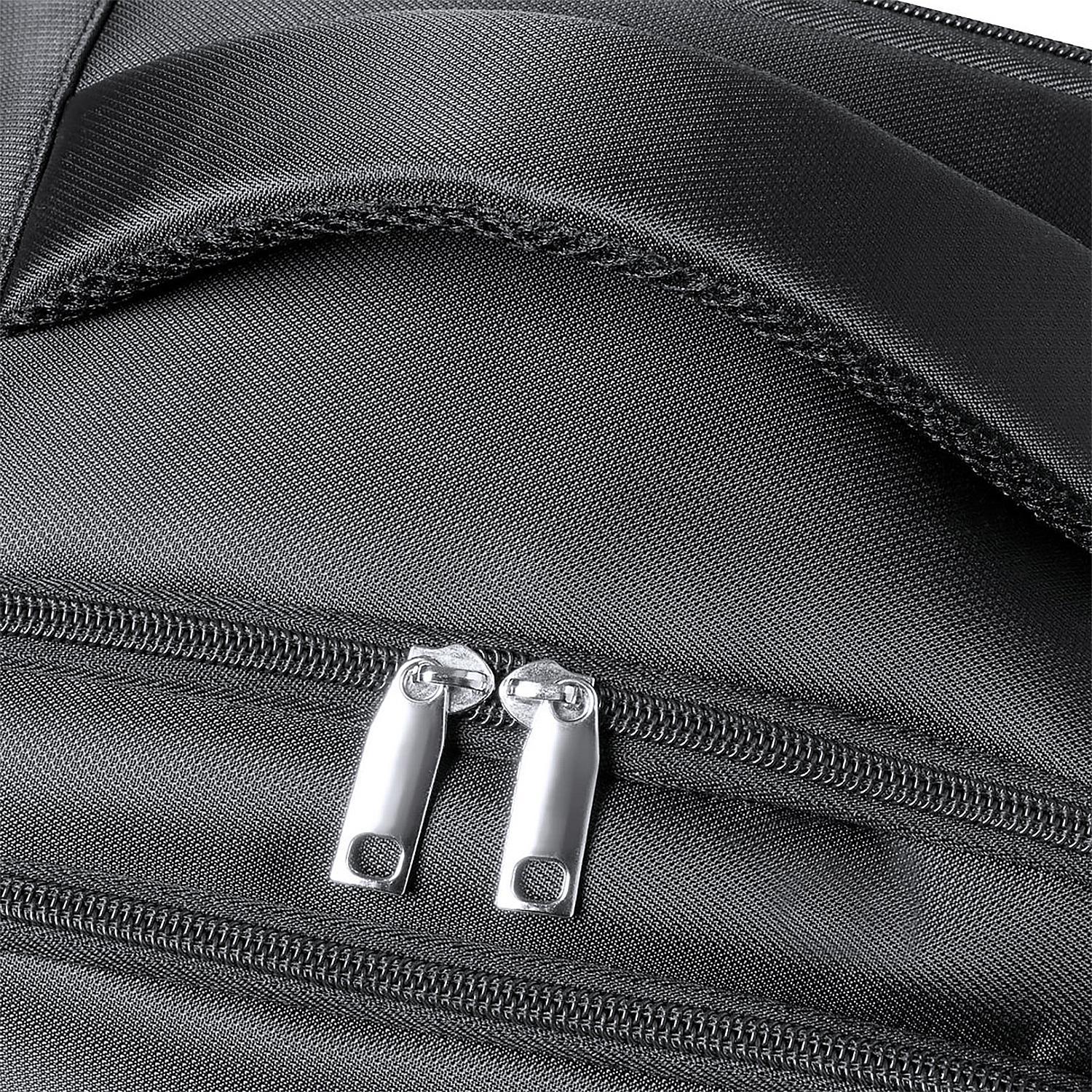 Primo piano di una borsa nera con due cerniere argentate e tessuto strutturato.