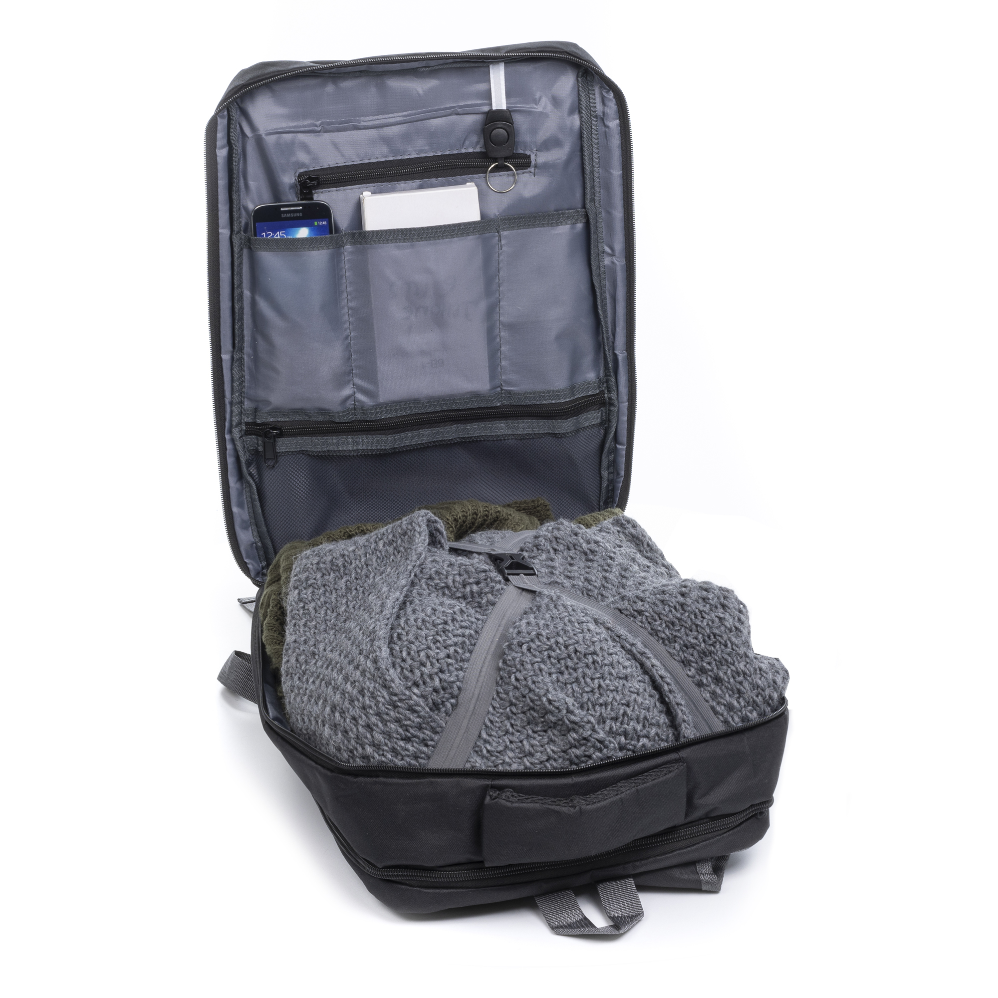 Schwarzer Rucksack, offen, mit Kleidung und Accessoires, vor weißem Hintergrund.