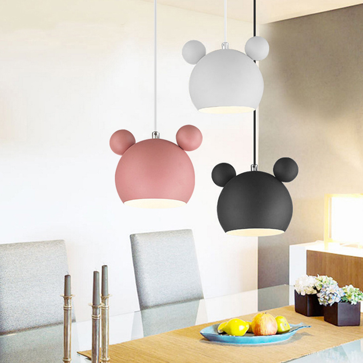Drei Pendelleuchten in Bärenform, in Weiß, Rosa und Schwarz, hängen von einer weißen Decke.