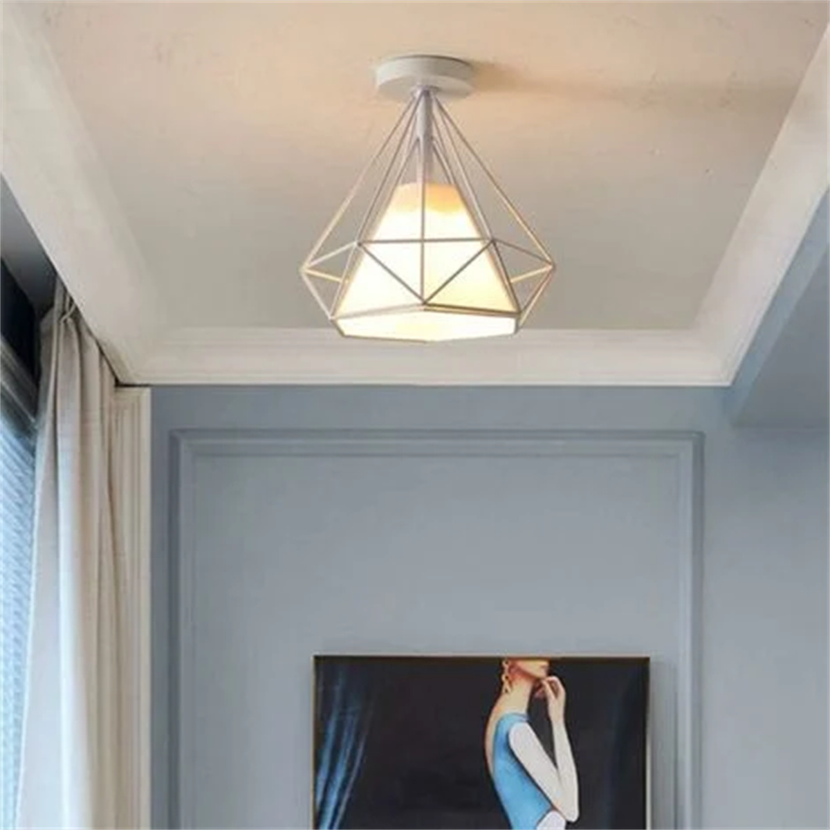 Geometrische Deckenlampe mit weißem Rahmen und warmem Licht. Sie ist an einer weißen Decke montiert.