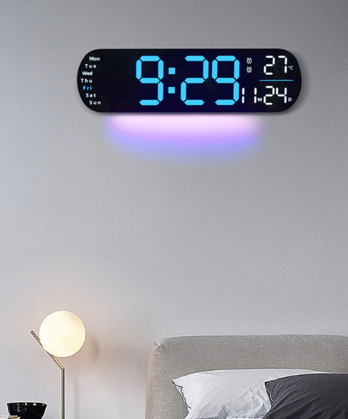 Digitale Uhr an einer Wand, die Zeit und Datum in blauem Licht anzeigt.