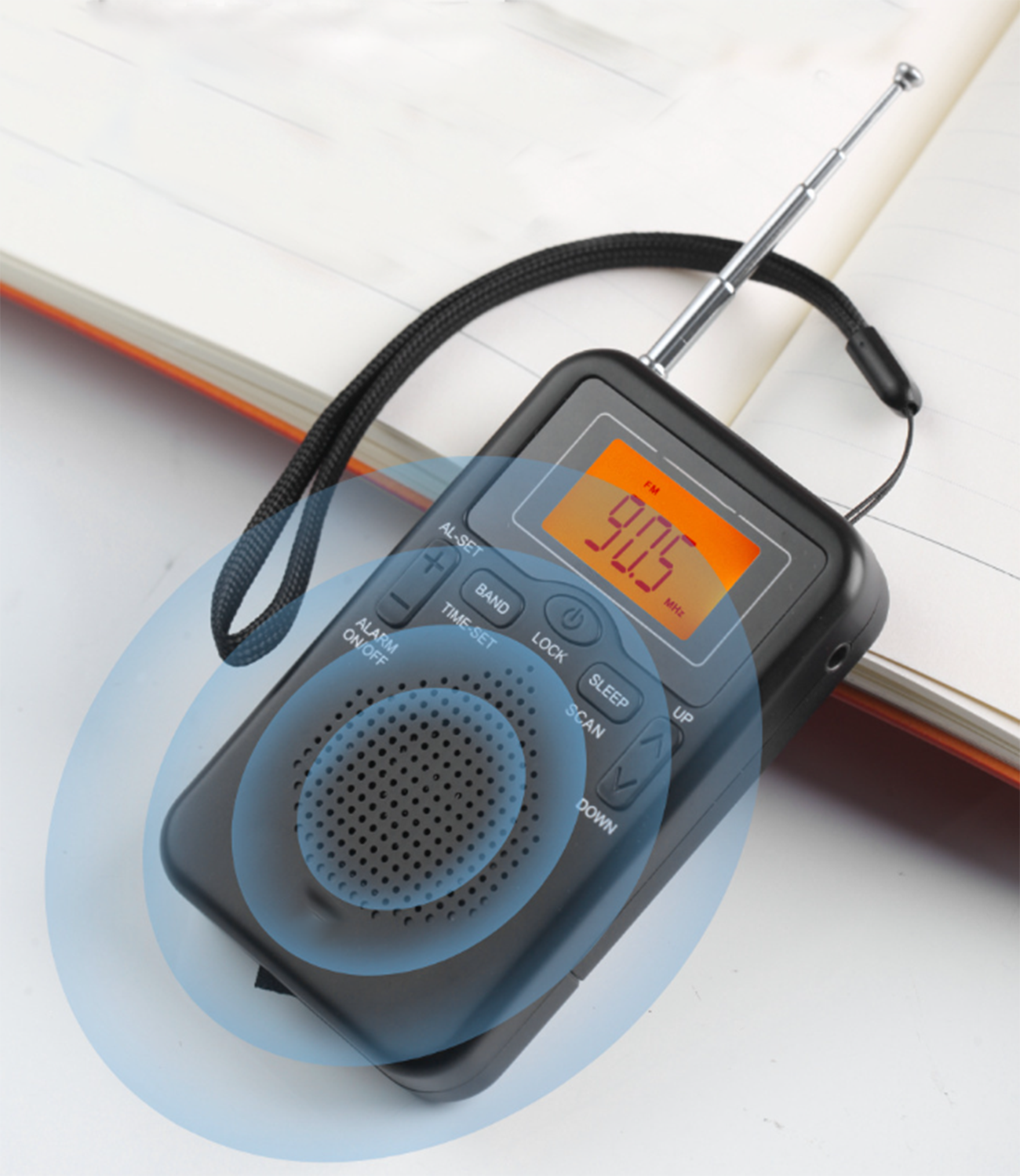 Kleines schwarzes Radio mit ausziehbarer Antenne und Digitalanzeige auf weißem Hintergrund.