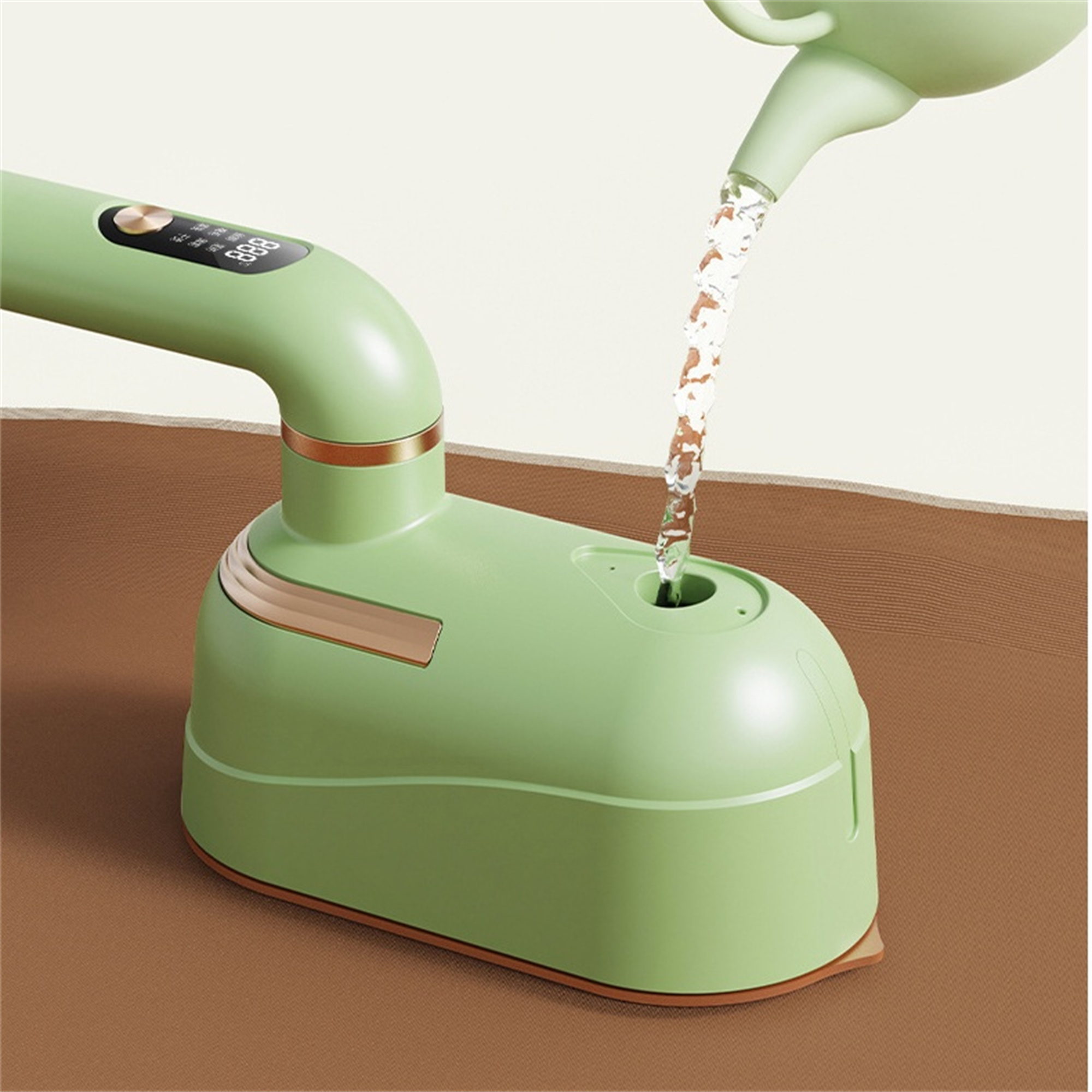 Grünes Bügeleisen mit Wasser, das hineingegossen wird, auf einer braunen Oberfläche.