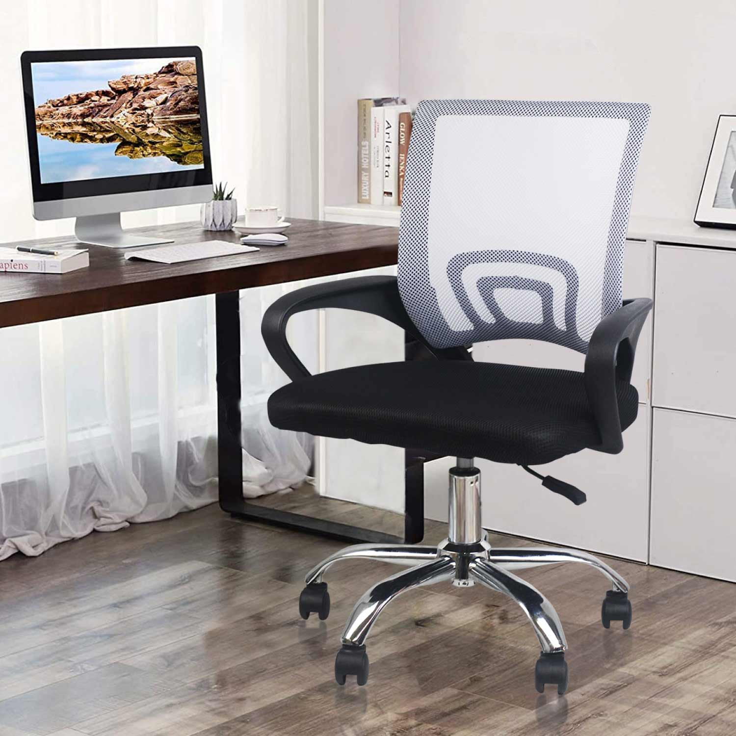 Silla de oficina con respaldo de malla blanca, en una habitación con escritorio y ordenador.