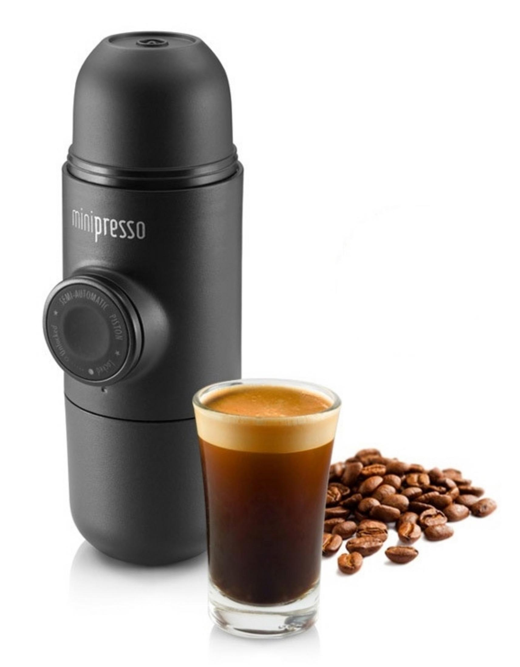 Ein schwarzer, tragbarer Espressomaschine mit einem Espresso und Kaffeebohnen.