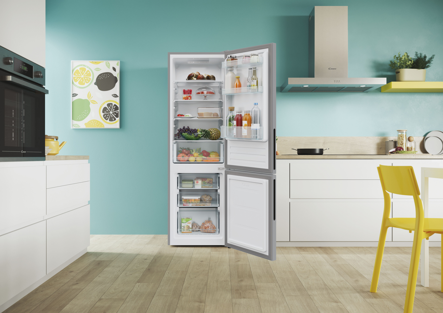 Cocina moderna con refrigerador abierto, mostrando comida adentro. Arte de limón en la pared.
