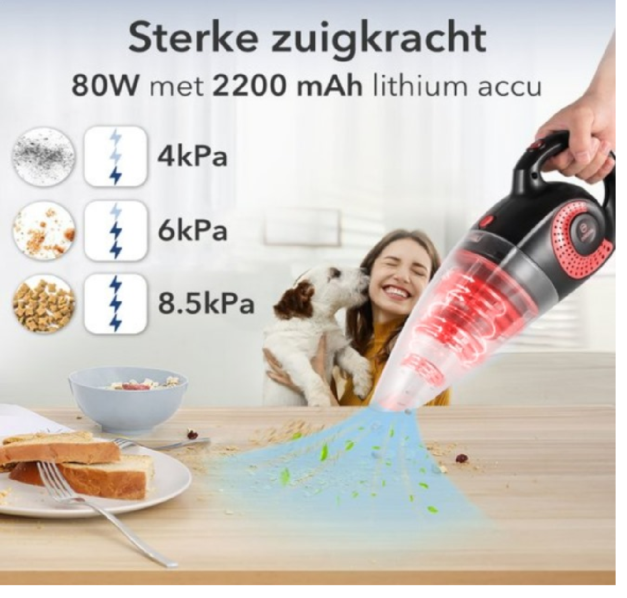 Frau mit Welpen neben Staubsauger auf Tisch. Staub und Essensreste sind sichtbar.