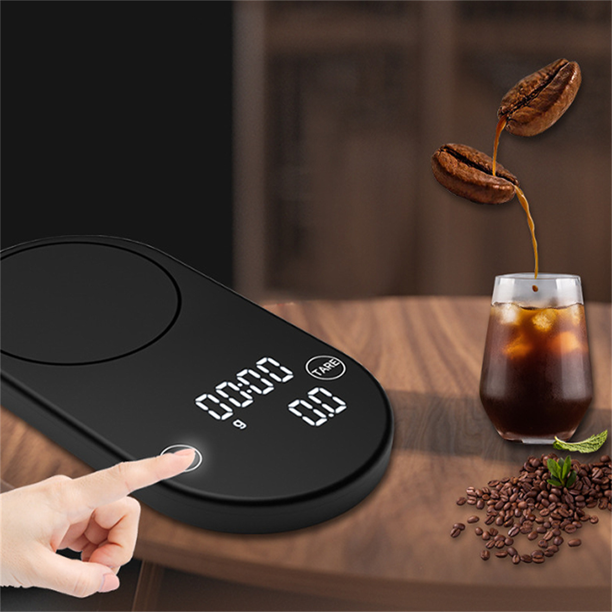 Eine schwarze Waage mit Touch-Taste, mit Kaffeebohnen und einem Glas Kaffee in der Nähe.