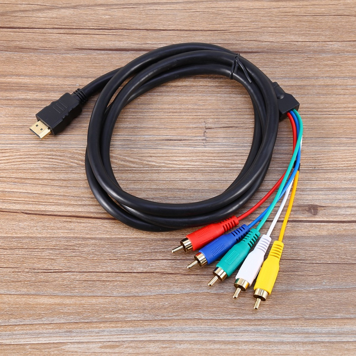 Schwarzes HDMI-Kabel mit mehrfarbigen Cinch-Anschlüssen auf einer Holzoberfläche.