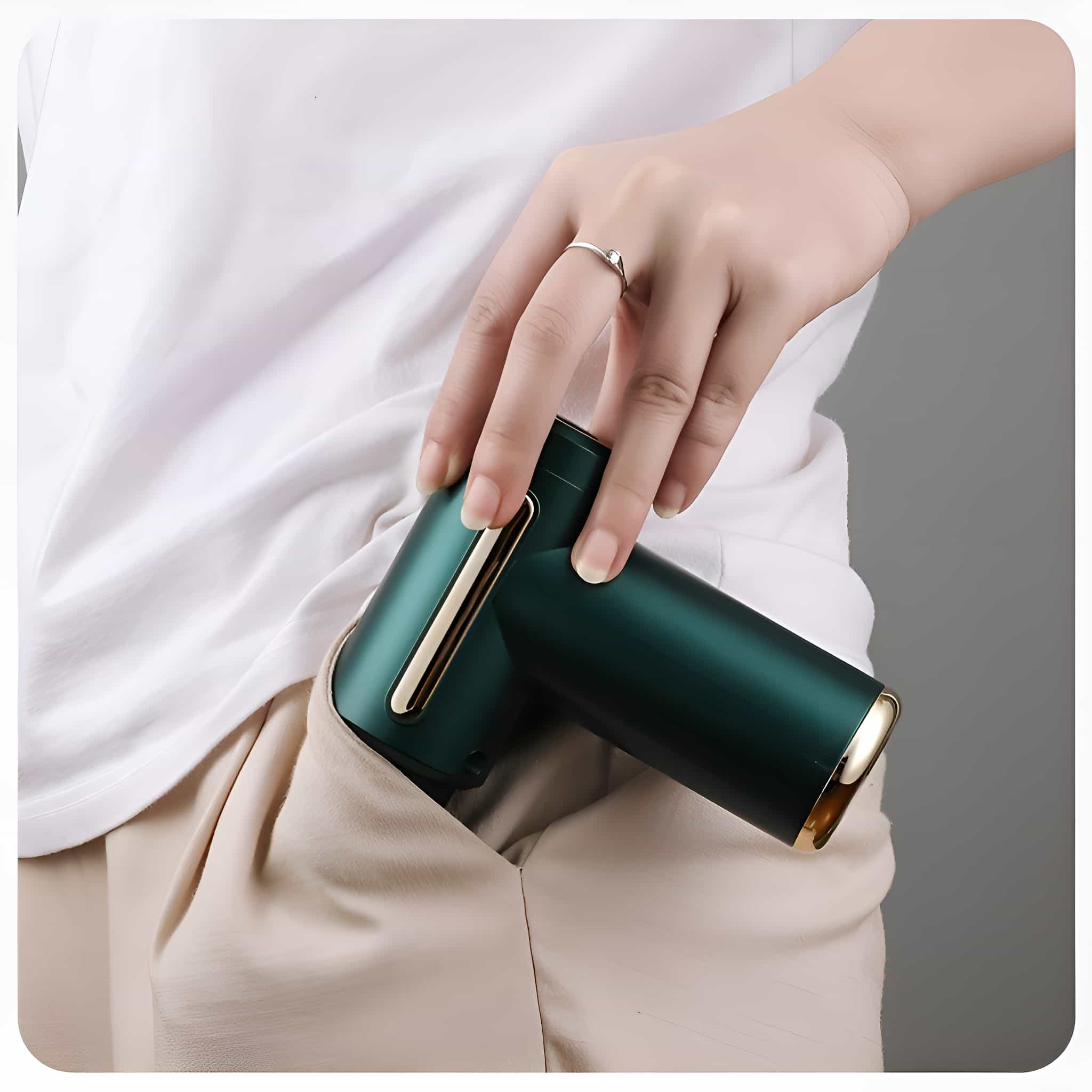 Die Hand einer Person in der Tasche hält ein kleines, grünes, zylindrisches Gerät mit Goldakzenten.