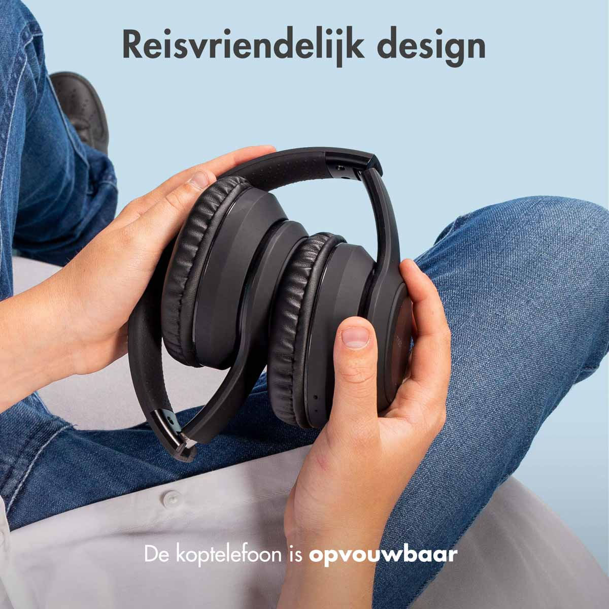 Handen die een opvouwbare zwarte koptelefoon vasthouden. Tekst: 'Reisvriendelijk design'.