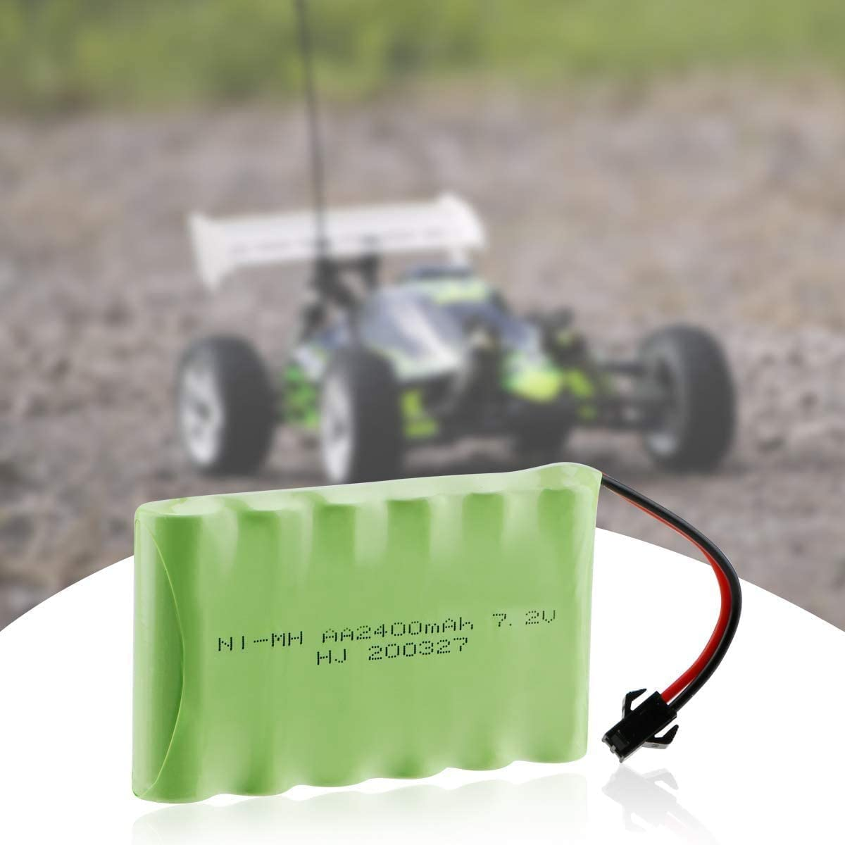 Grünes Akku-Pack mit schwarzen Drähten und Stecker. Verschwommener Hintergrund zeigt ein Spielzeugauto.