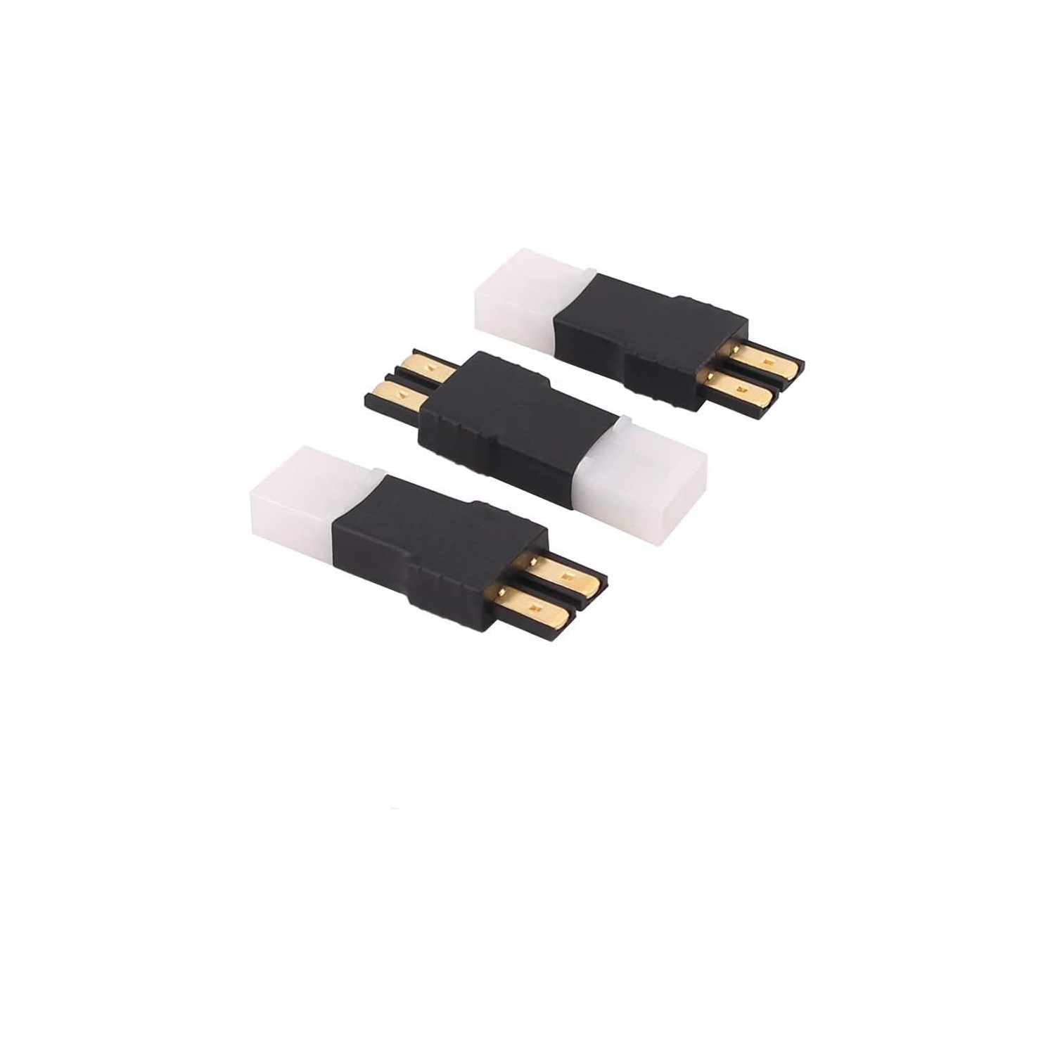 Drei weiße und schwarze Stecker auf einer weißen Oberfläche mit goldenen Anschlüssen.
