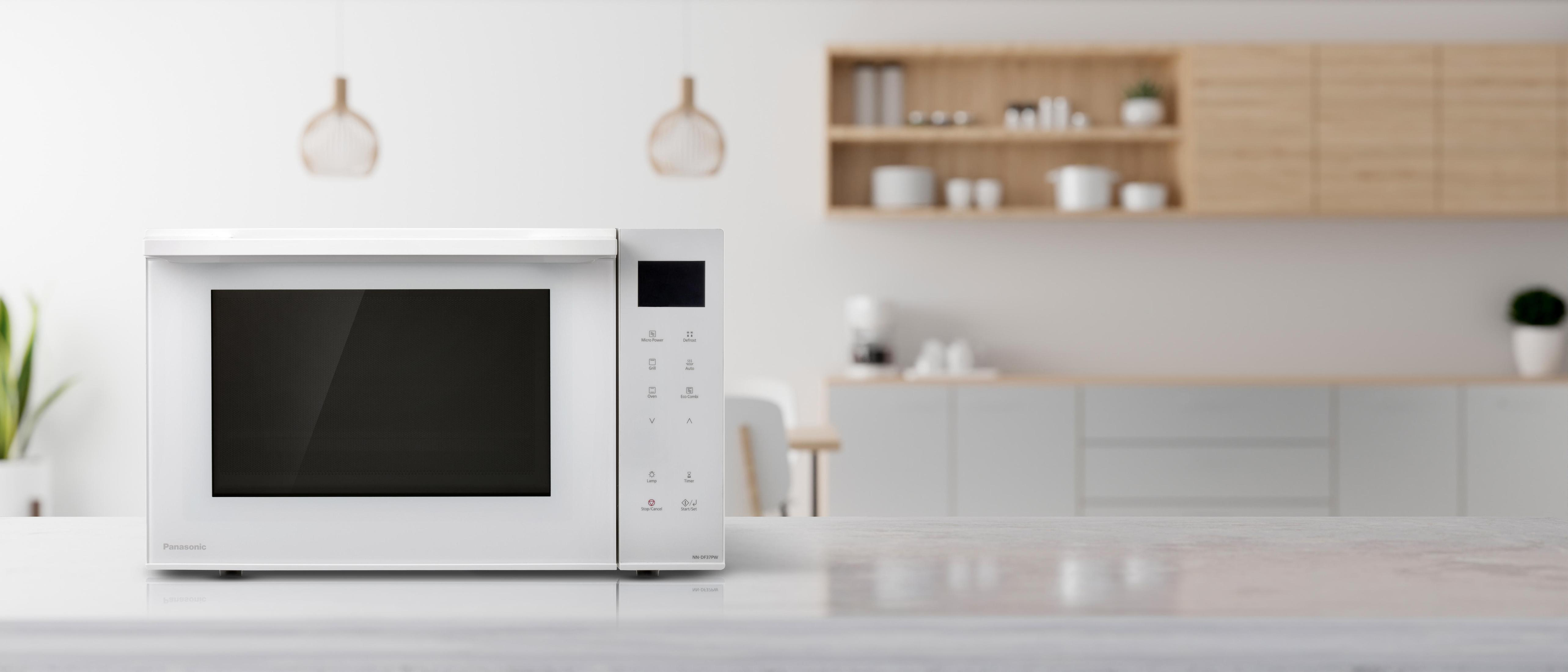 Biała kuchenka mikrofalowa na blacie w nowoczesnej kuchni.