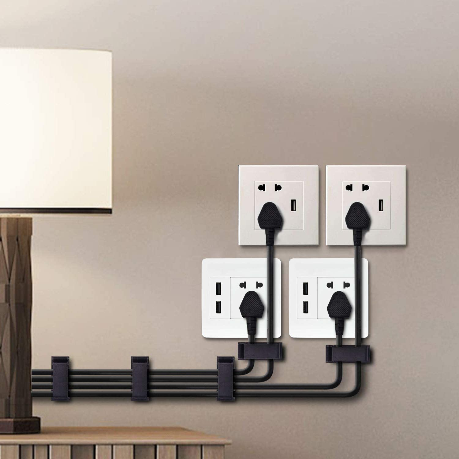 Wall with power outlets and black cables organized with cable clips.