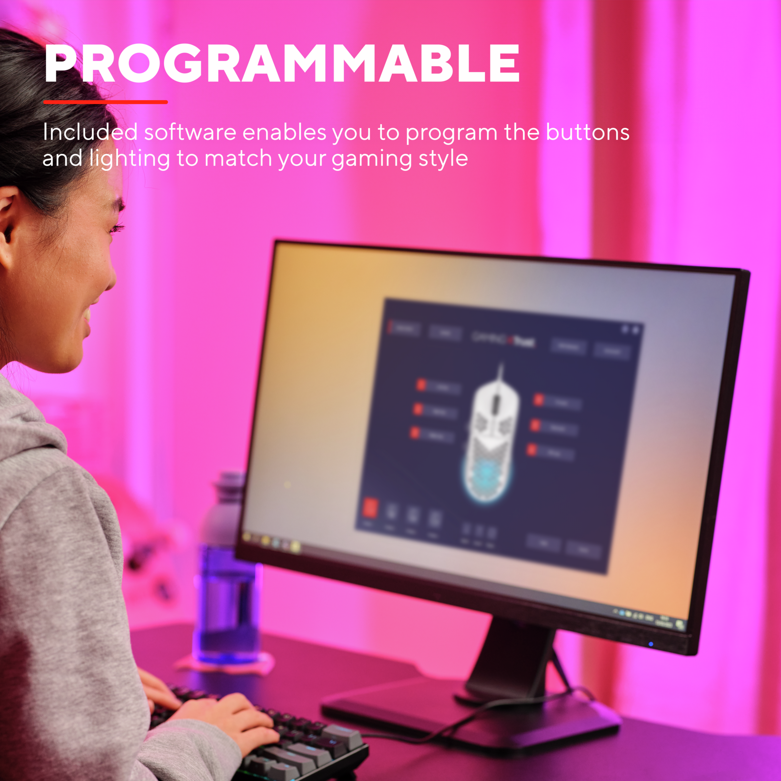 Kobieta używa klawiatury, patrząc na monitor z projektem myszy. Różowe tło.