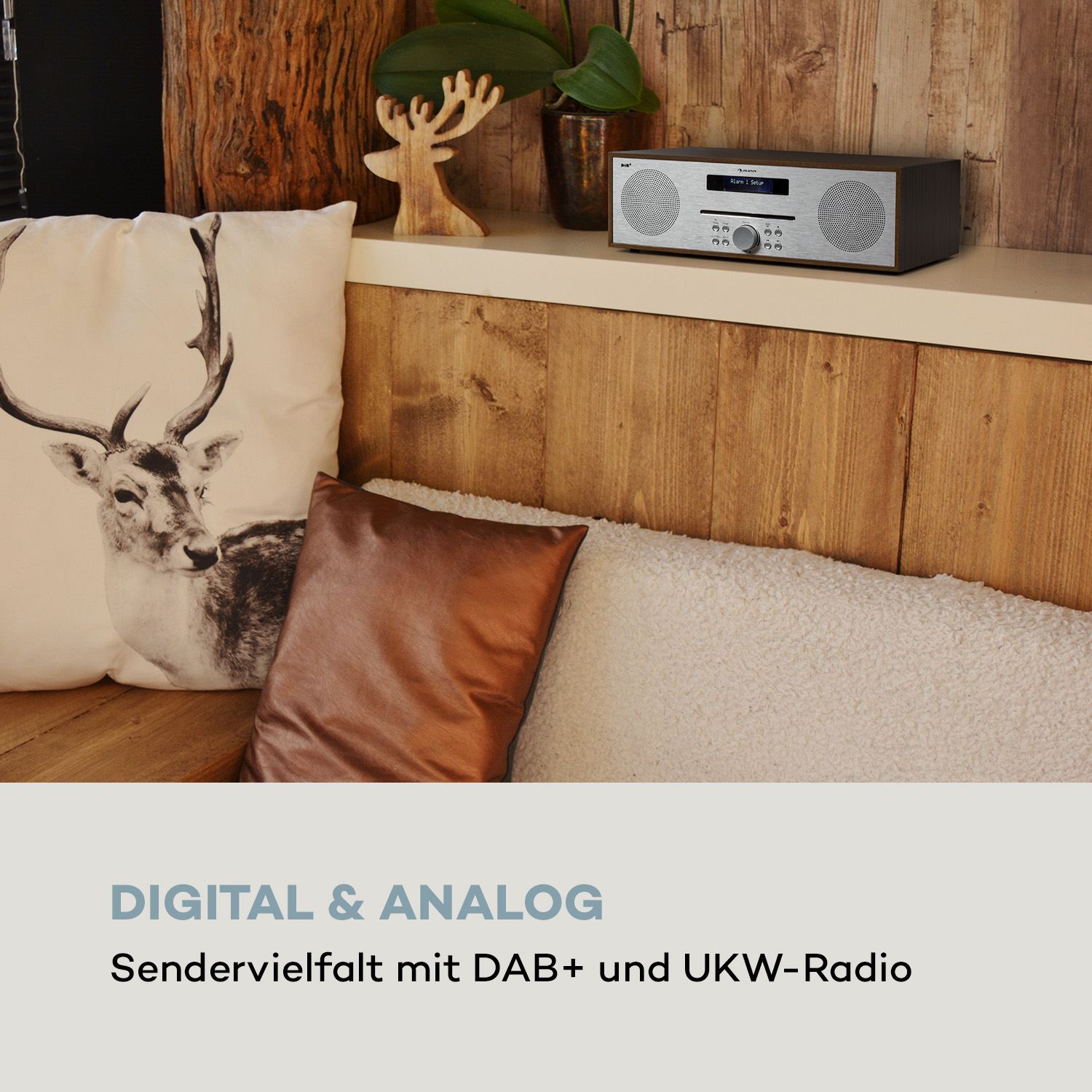 Holzregal mit Radio, Kissen und dekorativer Hirschfigur.