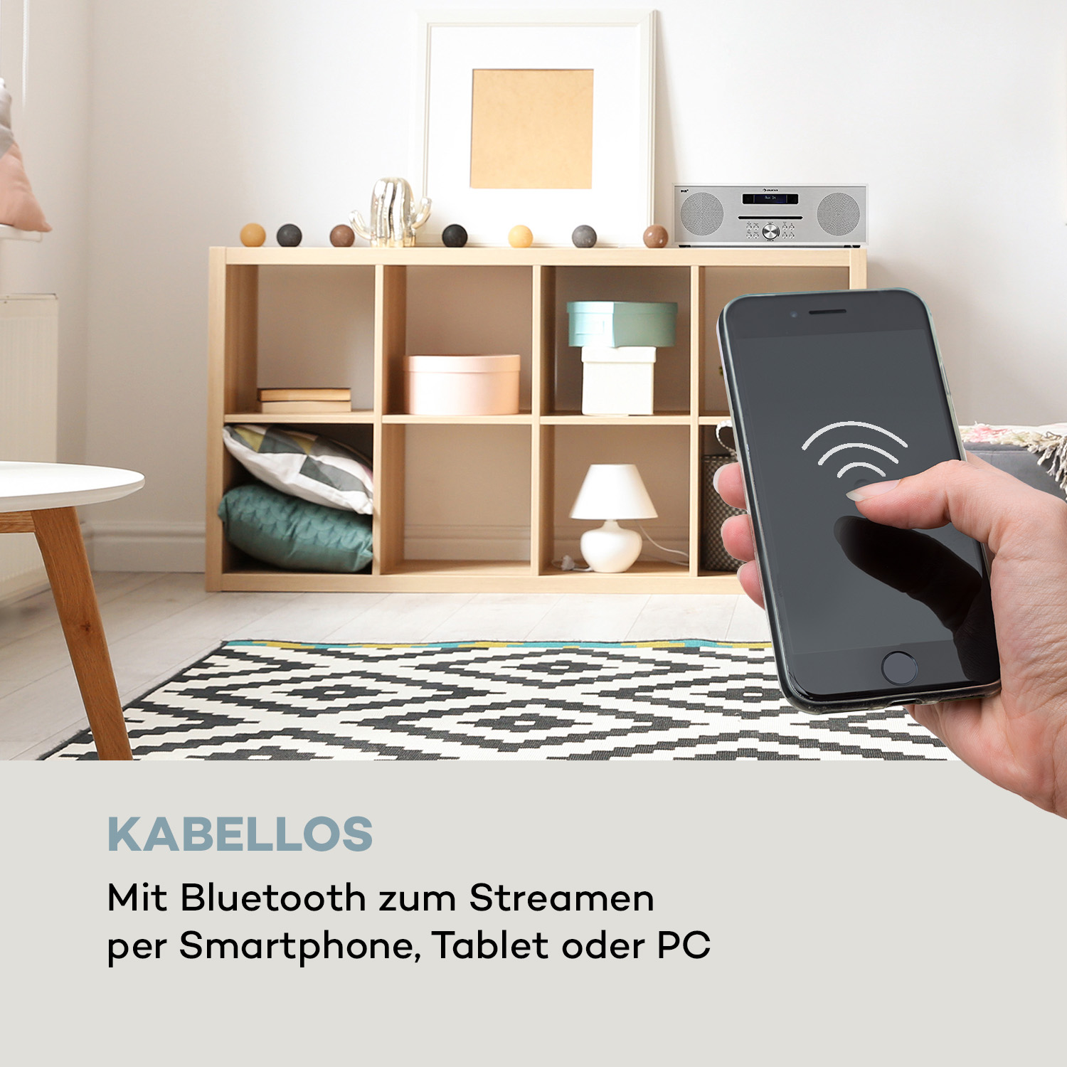 Hand, die ein schwarzes Smartphone mit einem WLAN-Symbol in der Nähe eines Stereos hält.