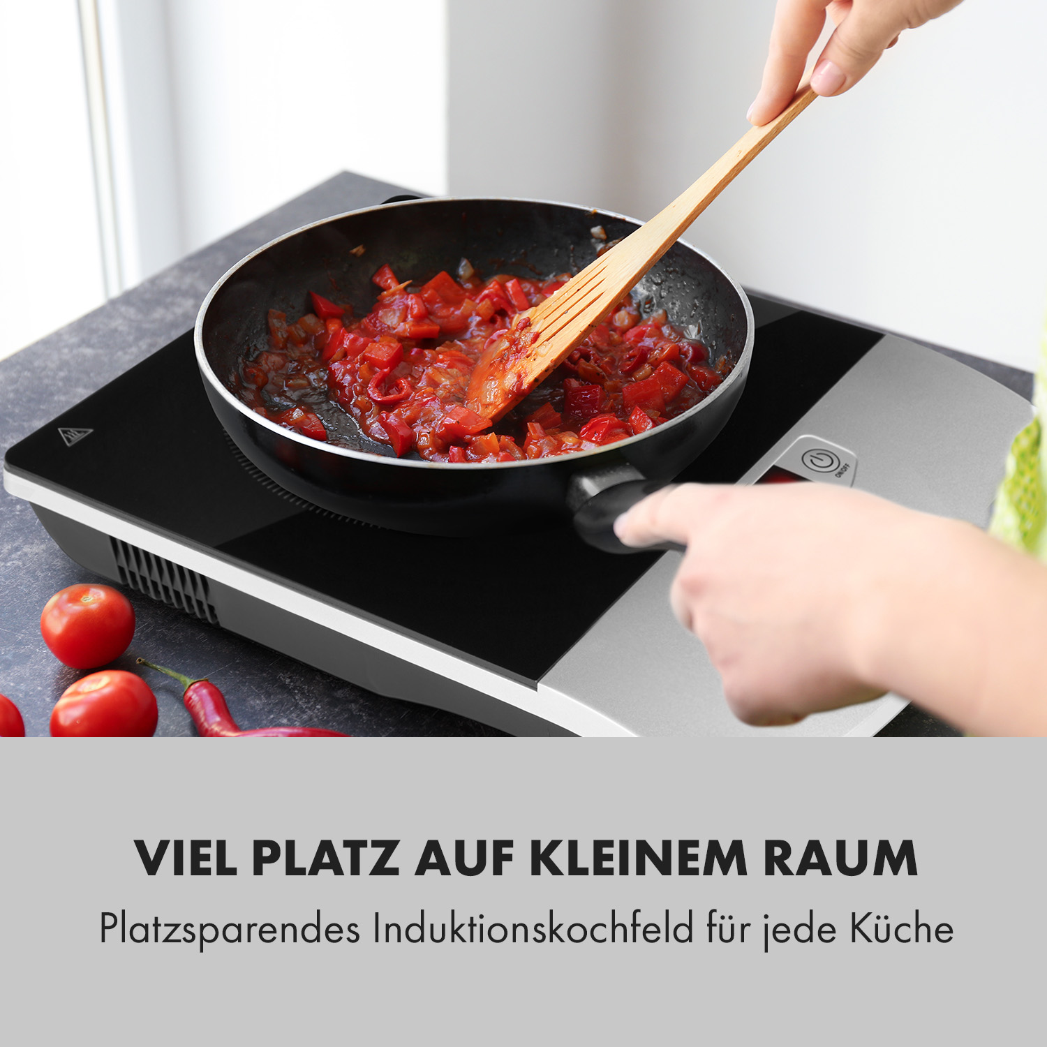 Person kocht in einer Pfanne auf einem Induktionskochfeld. Rote Paprika werden gekocht. Text: Viel Platz.