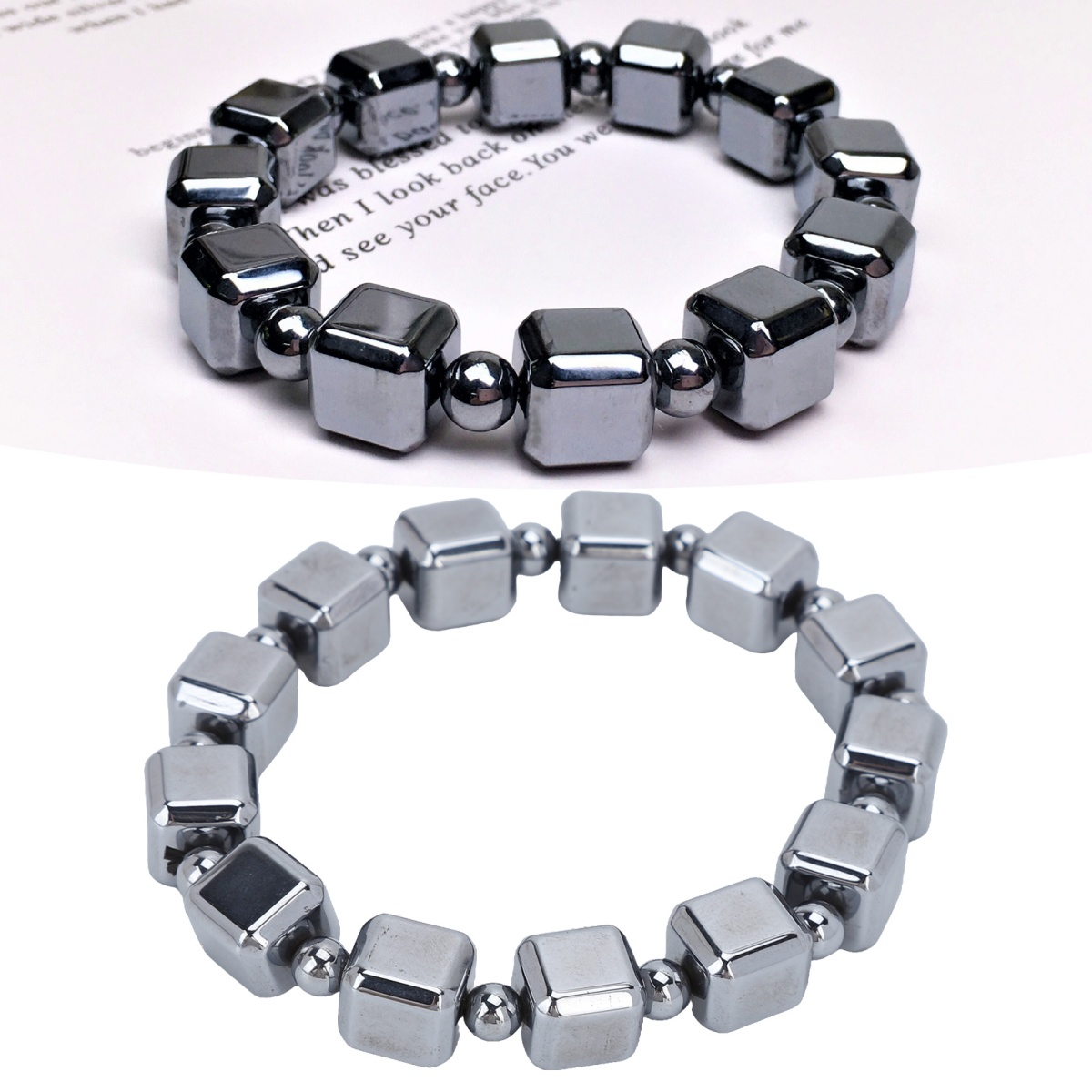 Zwei Armbänder aus dunkelgrauen Magnetwürfeln, eins auf Papier.