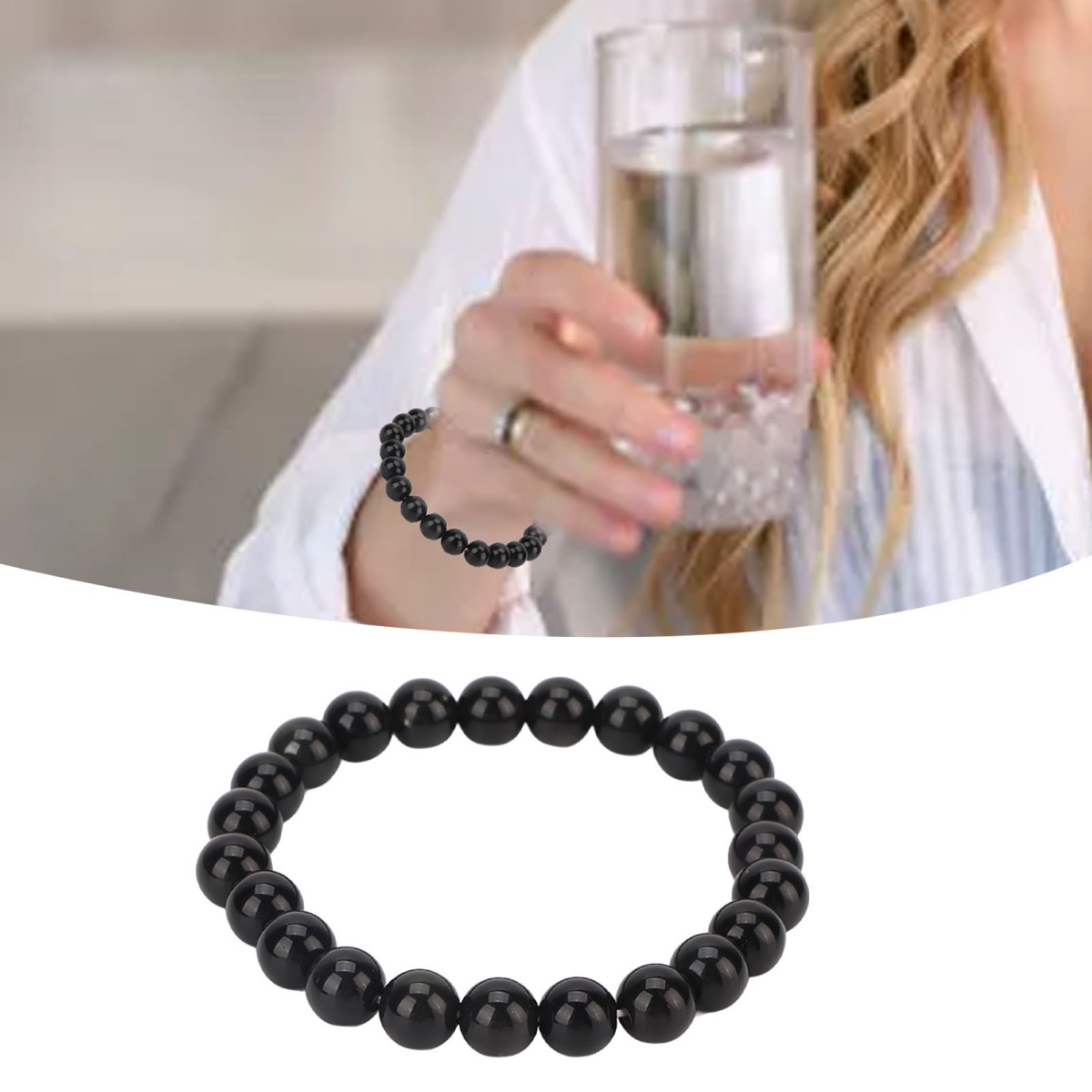 Nahaufnahme eines schwarzen Perlenarmbands, im Hintergrund eine Person mit einem Glas Wasser.