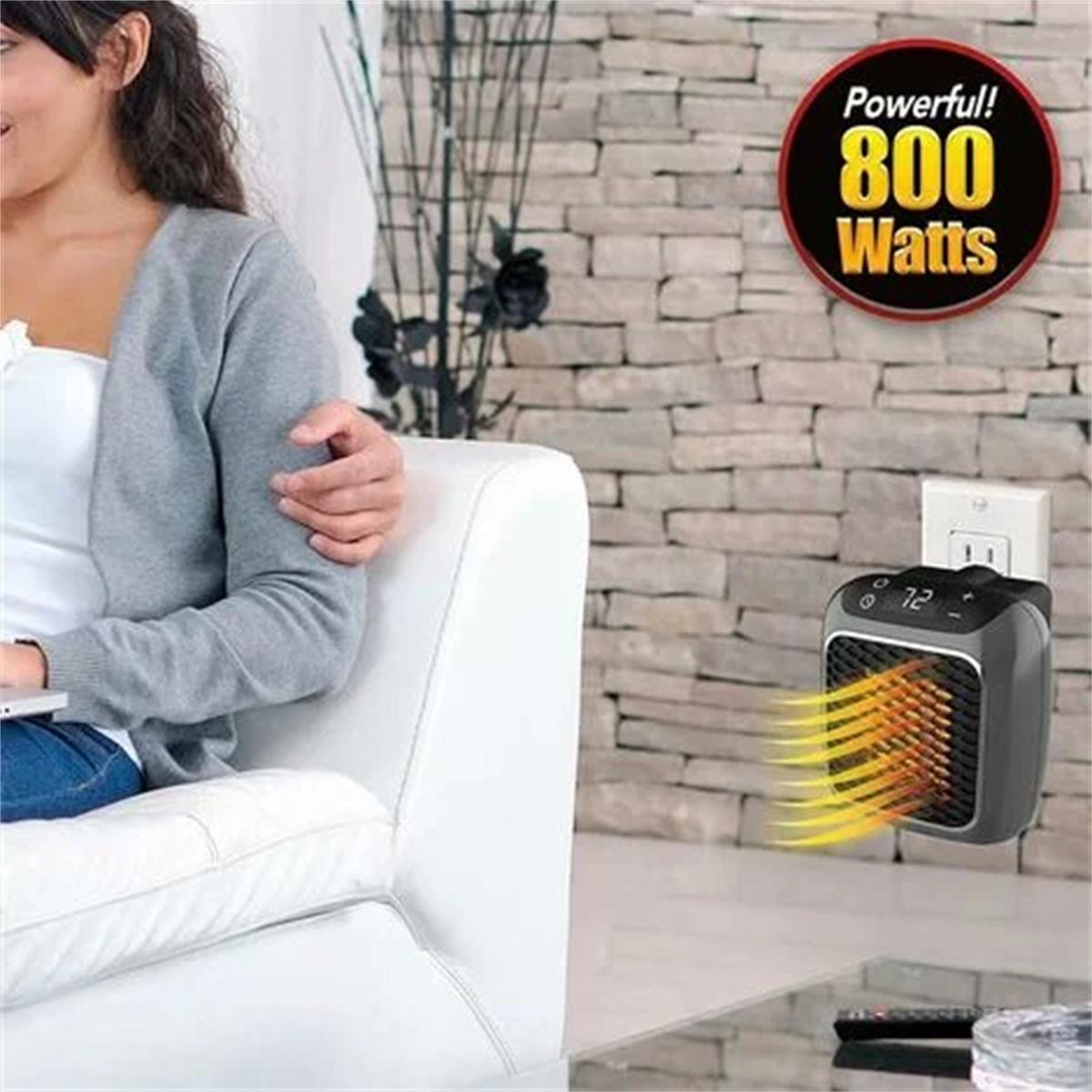 Ein kleiner schwarzer Heizlüfter ist in eine Wand gesteckt. Text: Leistungsstark! 800 Watt. Eine Frau sitzt auf einem weißen Sofa.