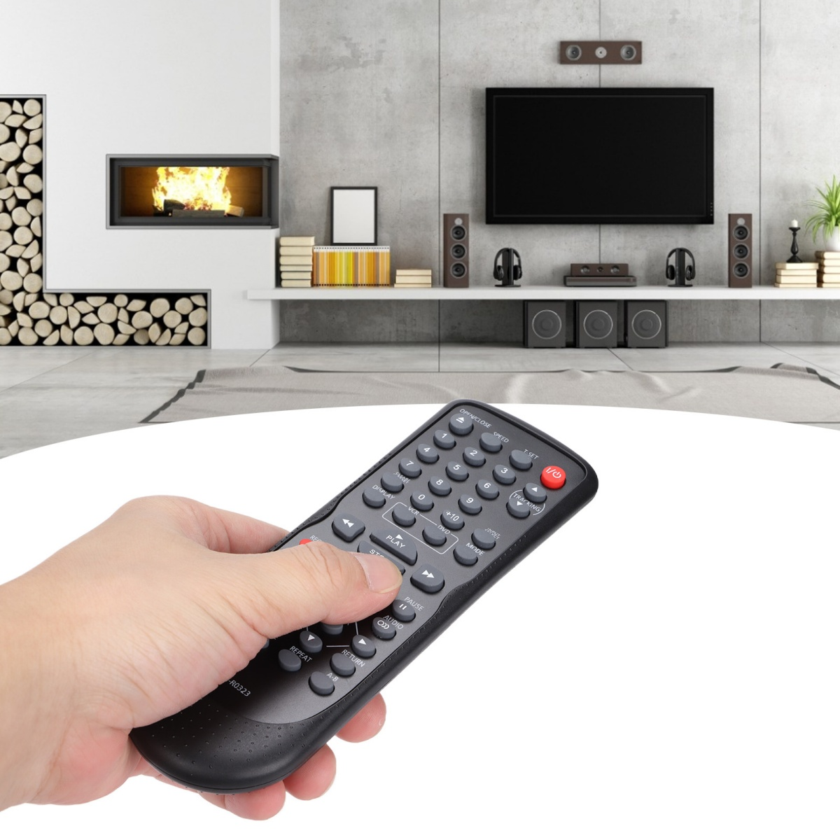 Hand mit schwarzer Fernbedienung, Wohnzimmer mit Fernseher und Kamin im Hintergrund.