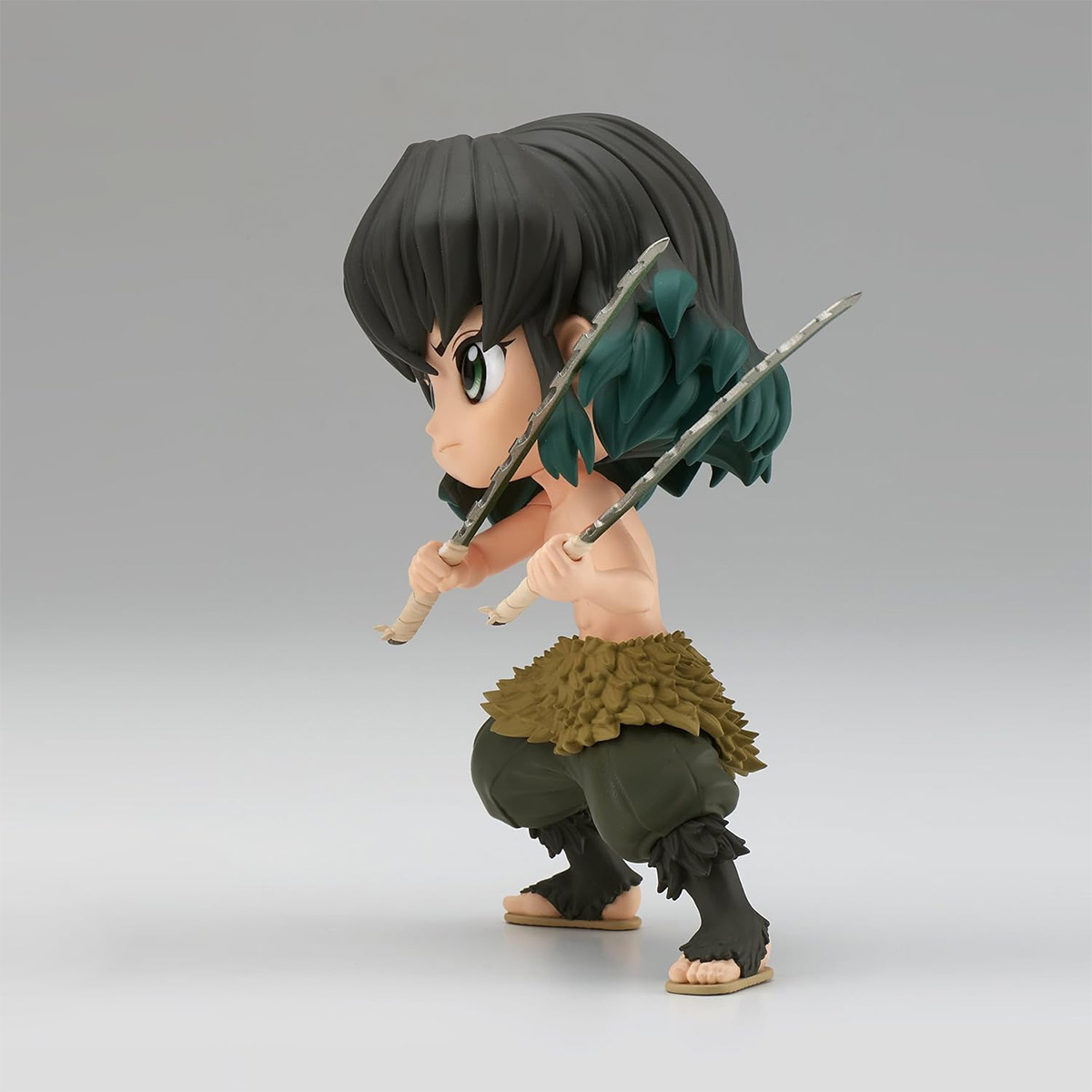Eine kleine Anime-Figur eines Charakters, der Schwerter hält und ein Pelzkleidungsstück trägt.