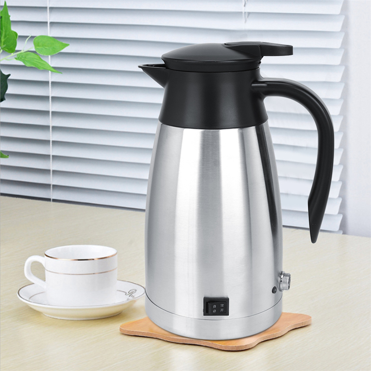 Elektrischer Edelstahlkessel mit schwarzem Griff und Deckel, auf Holzsockel.