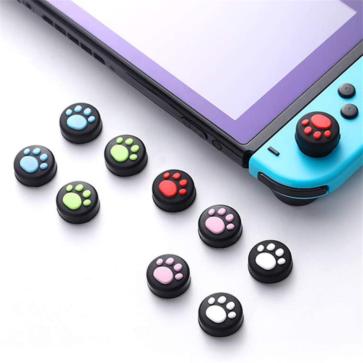 Eine Spielkonsole und Controller-Daumengriffe in verschiedenen Farben und Pfotendesigns.