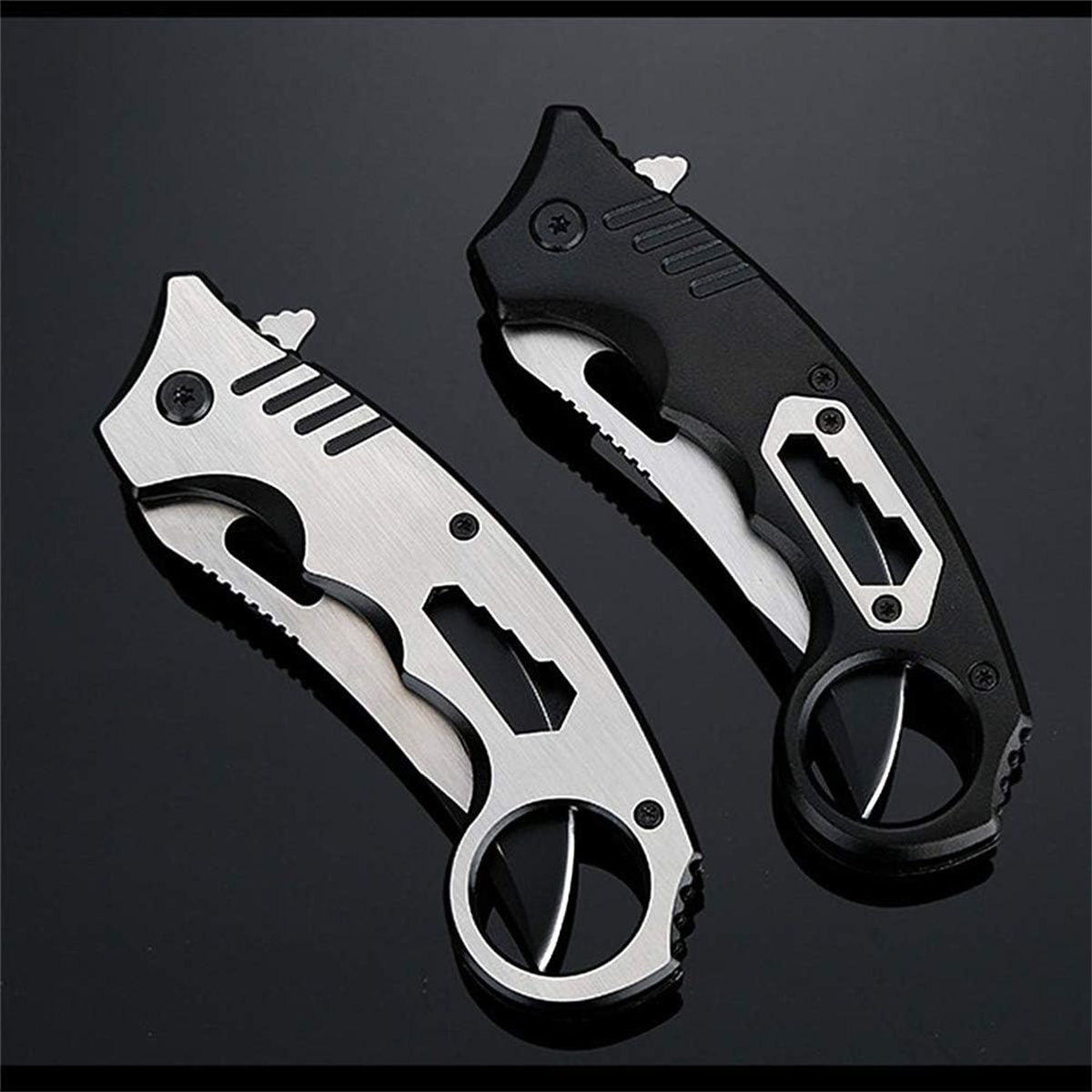 Zwei Klappmesser, eines silberfarben, eines schwarz, mit Fingerringen und verschiedenen Werkzeugen.