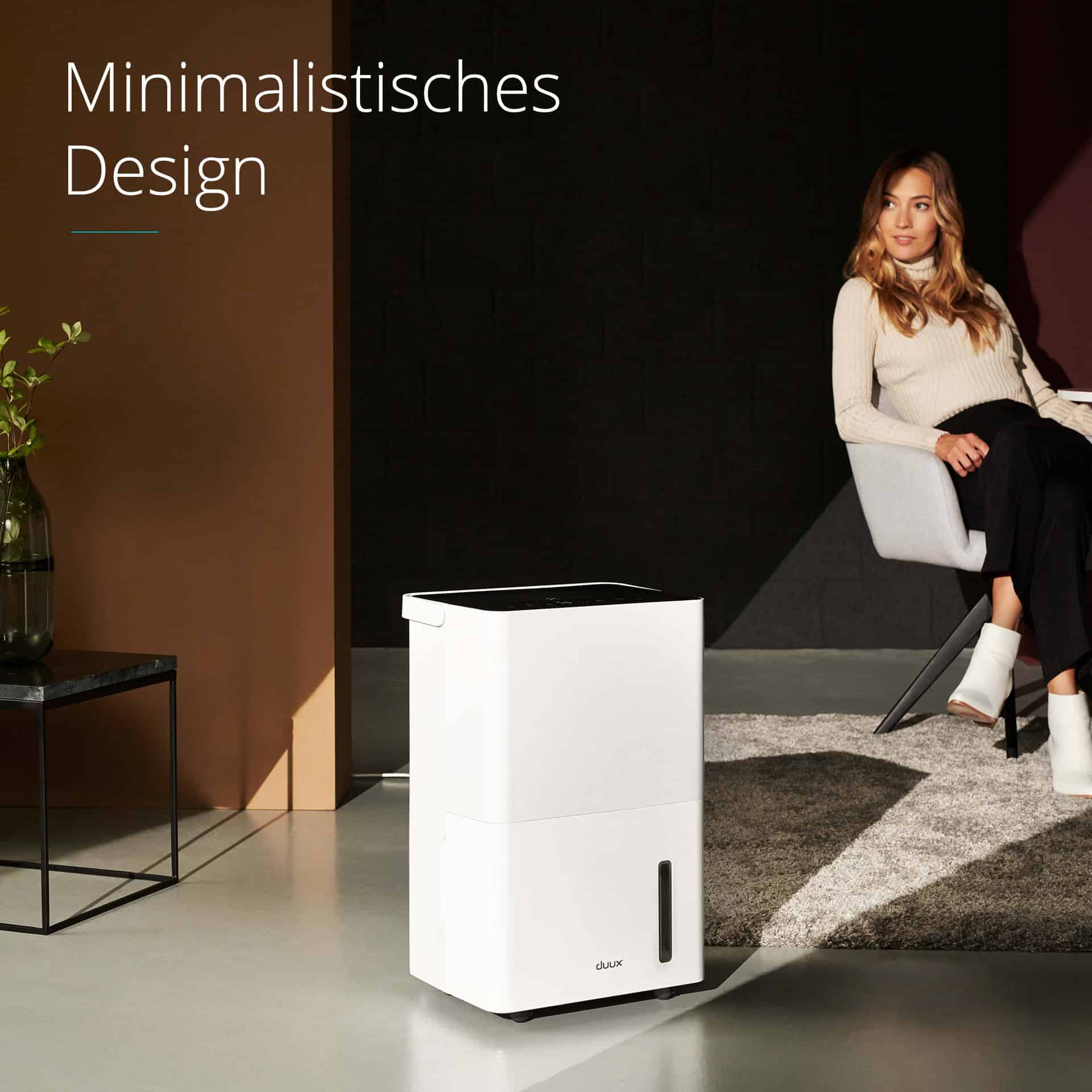 White dehumidifier with a woman in a chair, minimalist design in a room.