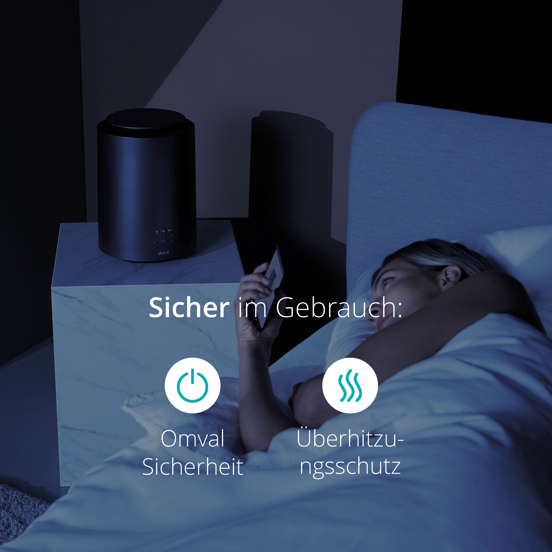 Kobieta w łóżku patrząca na telefon. Czarny nawilżacz na białym stoliku obok łóżka.