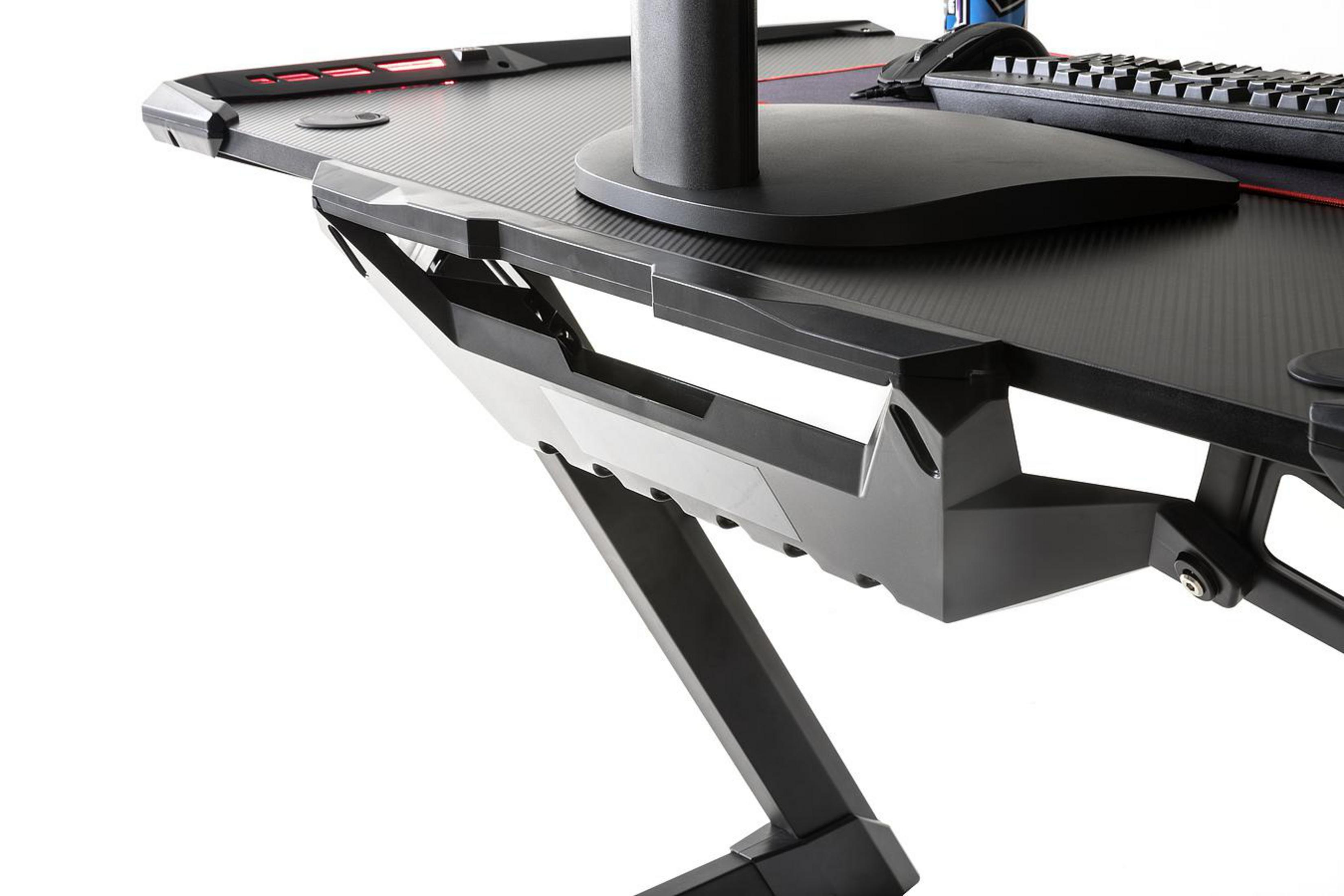 Close-up van een zwarte gamingtafel. De tafel heeft een monitorbevestiging en een bekerhouder.