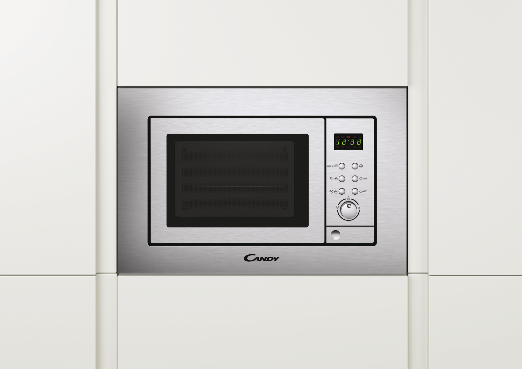 Srebrna kuchenka mikrofalowa wbudowana w białą szafkę kuchenną z przyciskami i wyświetlaczem.