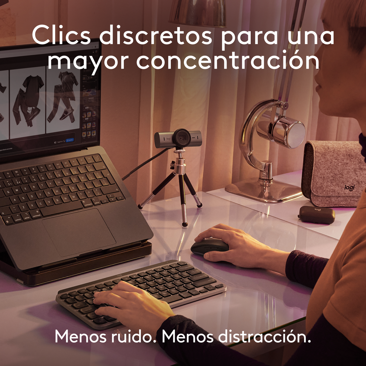 Una persona usa un laptop con webcam, tastiera e mouse su una scrivania.