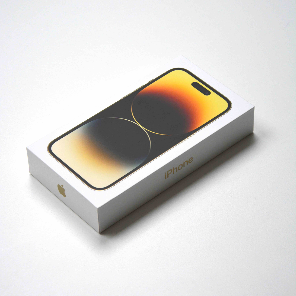 Pudełko iPhone, białe ze złotym zdjęciem telefonu, na białym tle.