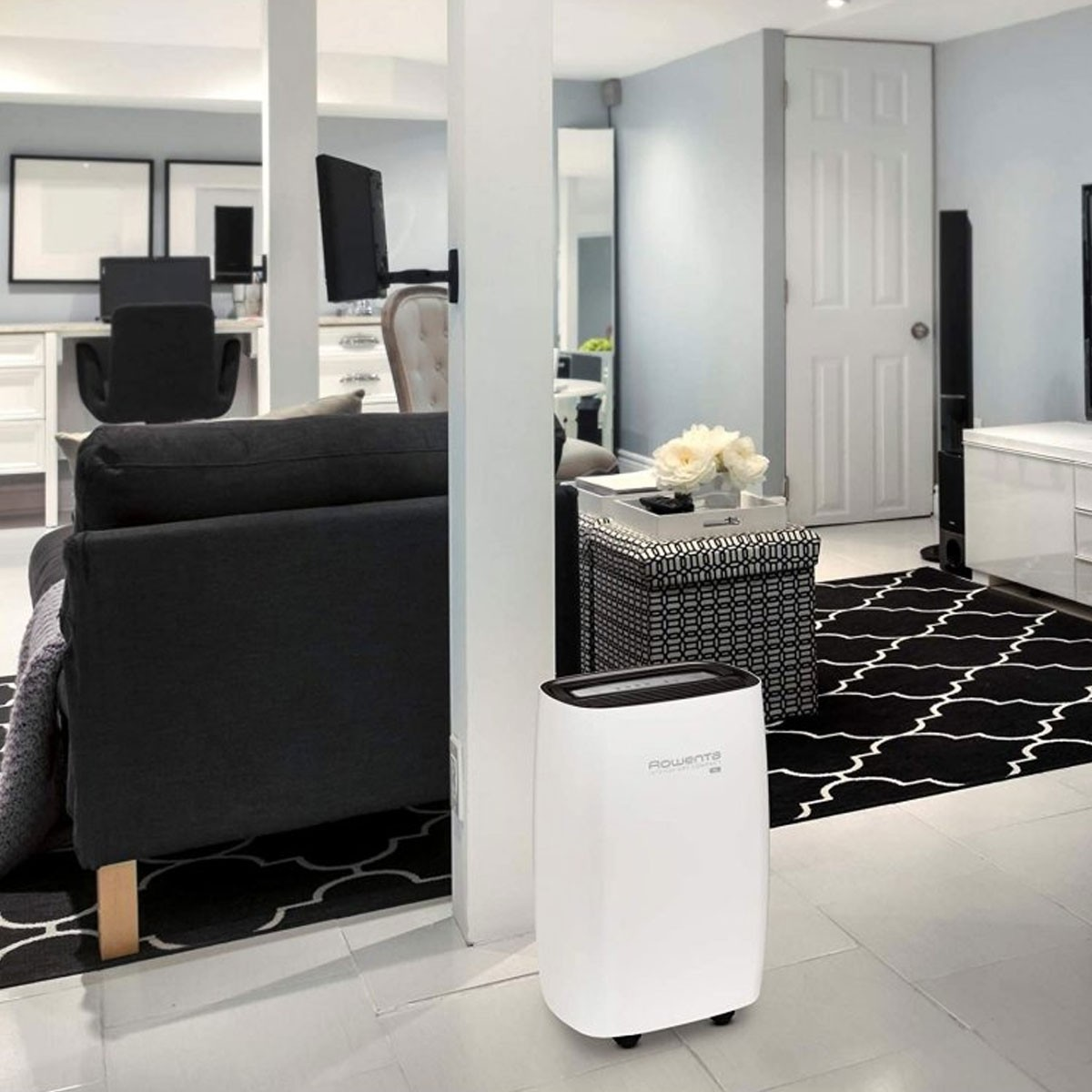 Stanza interna con un purificatore d'aria Rowenta bianco, arredamento bianco e nero.
